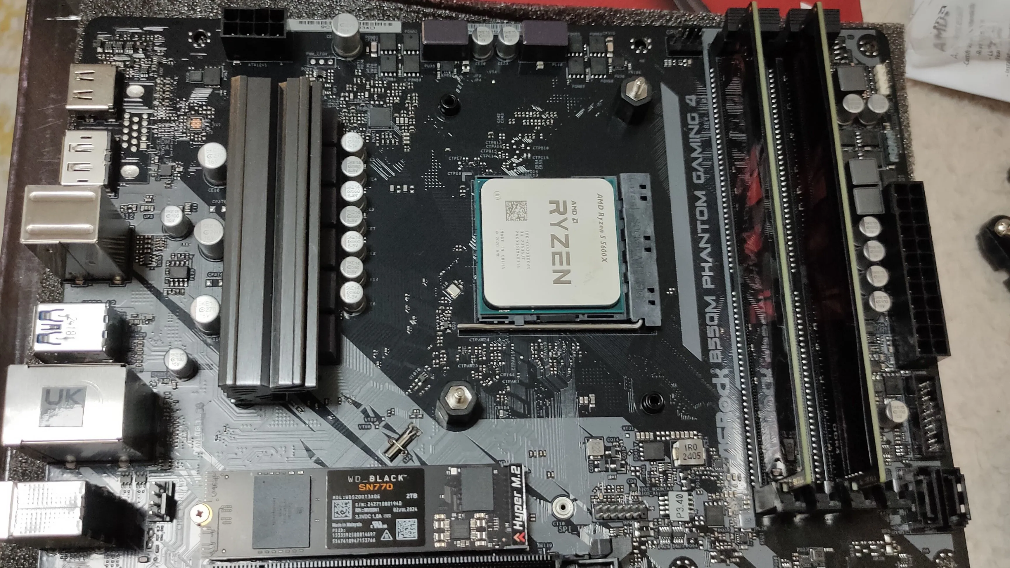 Bên trong máy tính PC chơi game với CPU Ryzen 5 5600X, bo mạch chủ B550M, RAM DDR4 và SSD NVMe, minh họa cấu hình nâng cấp
