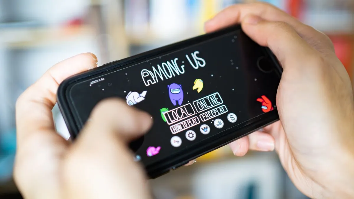 Cận cảnh đôi tay đang chơi game Among Us trên điện thoại thông minh