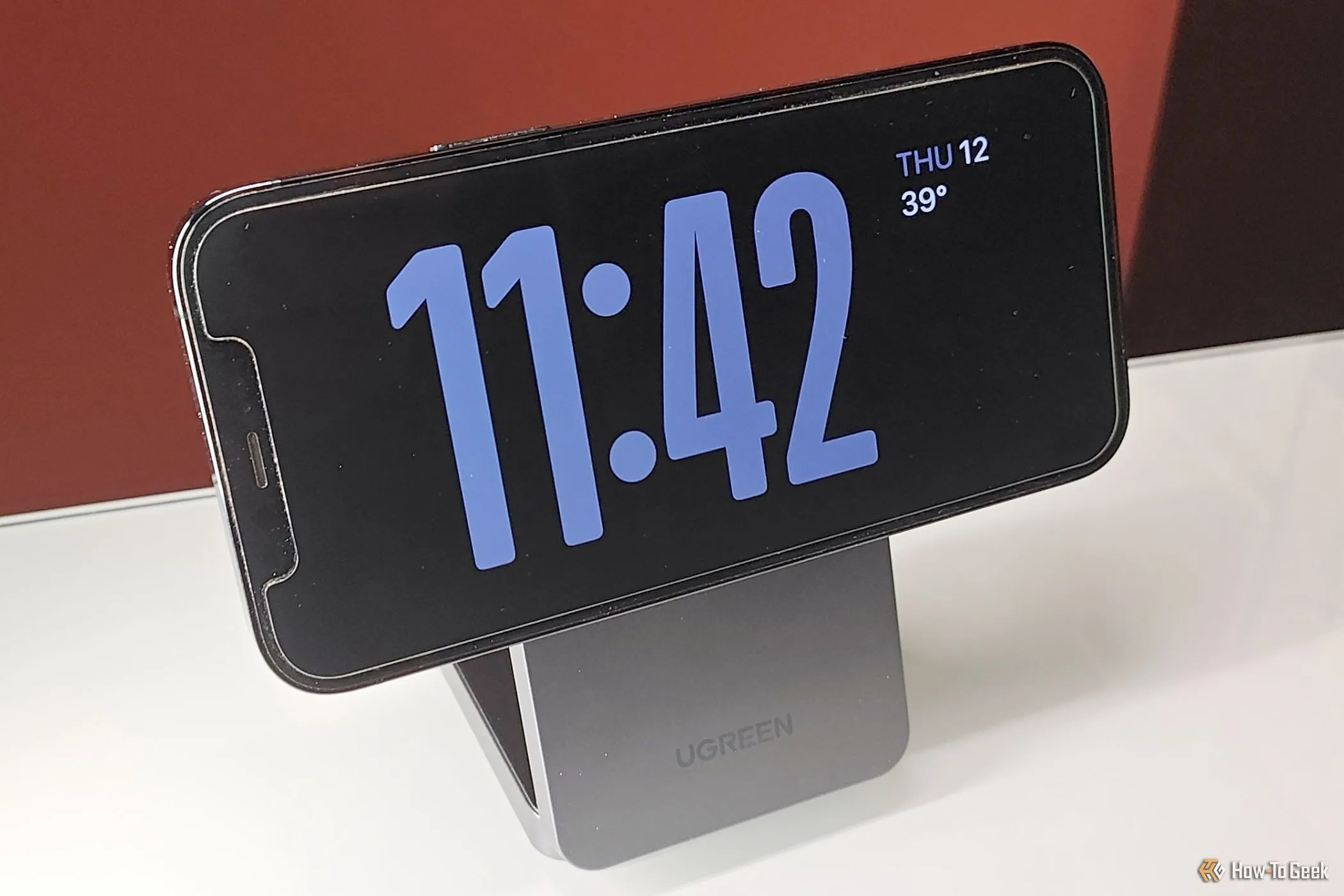 Góc nhìn cận cảnh iPhone đang hiển thị chế độ StandBy trên chân đế sạc không dây MagFlow Qi2
