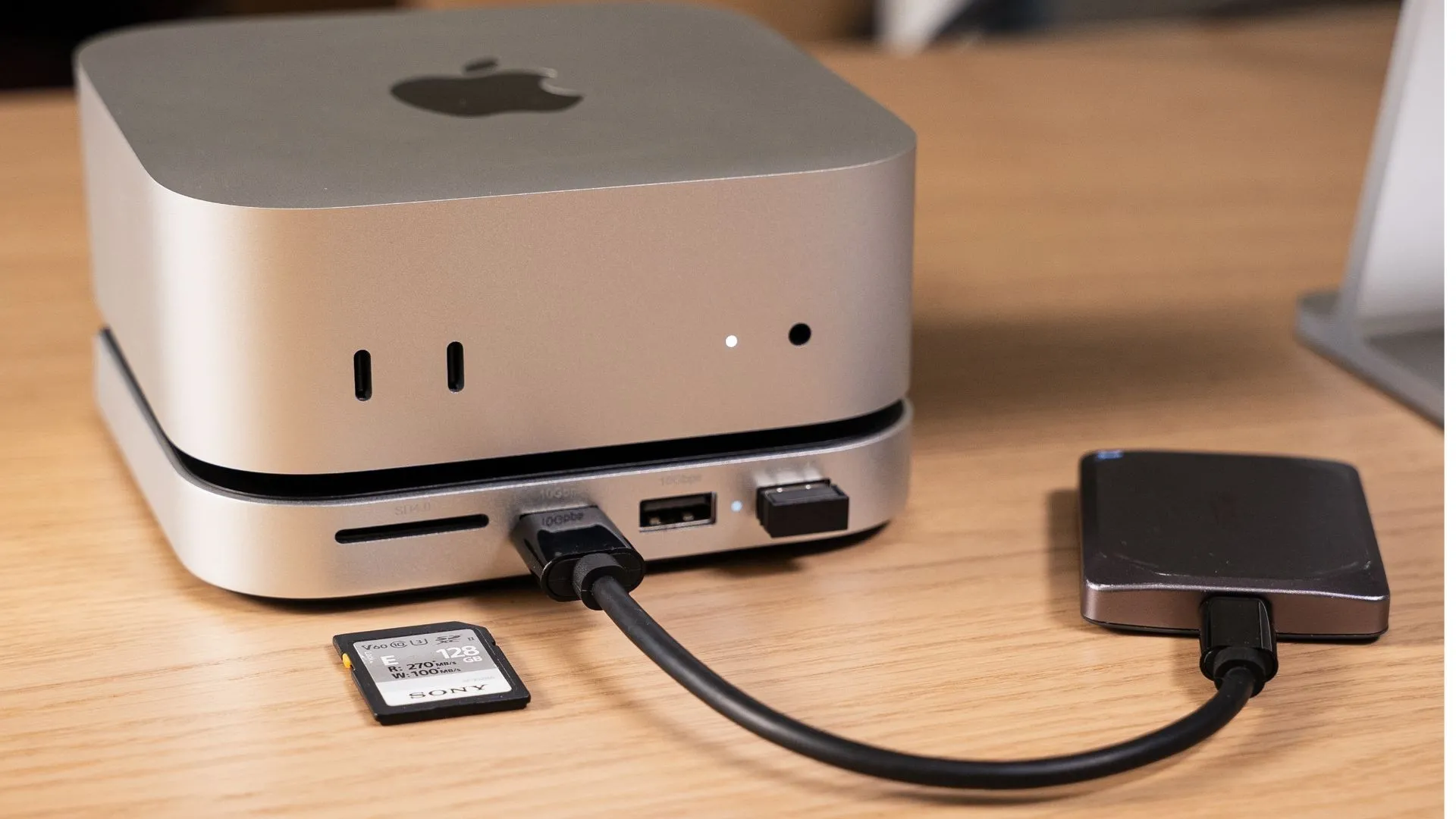 Mac mini màu bạc đặt trên một hub Satechi màu xám, hiển thị các cổng kết nối phía trước.