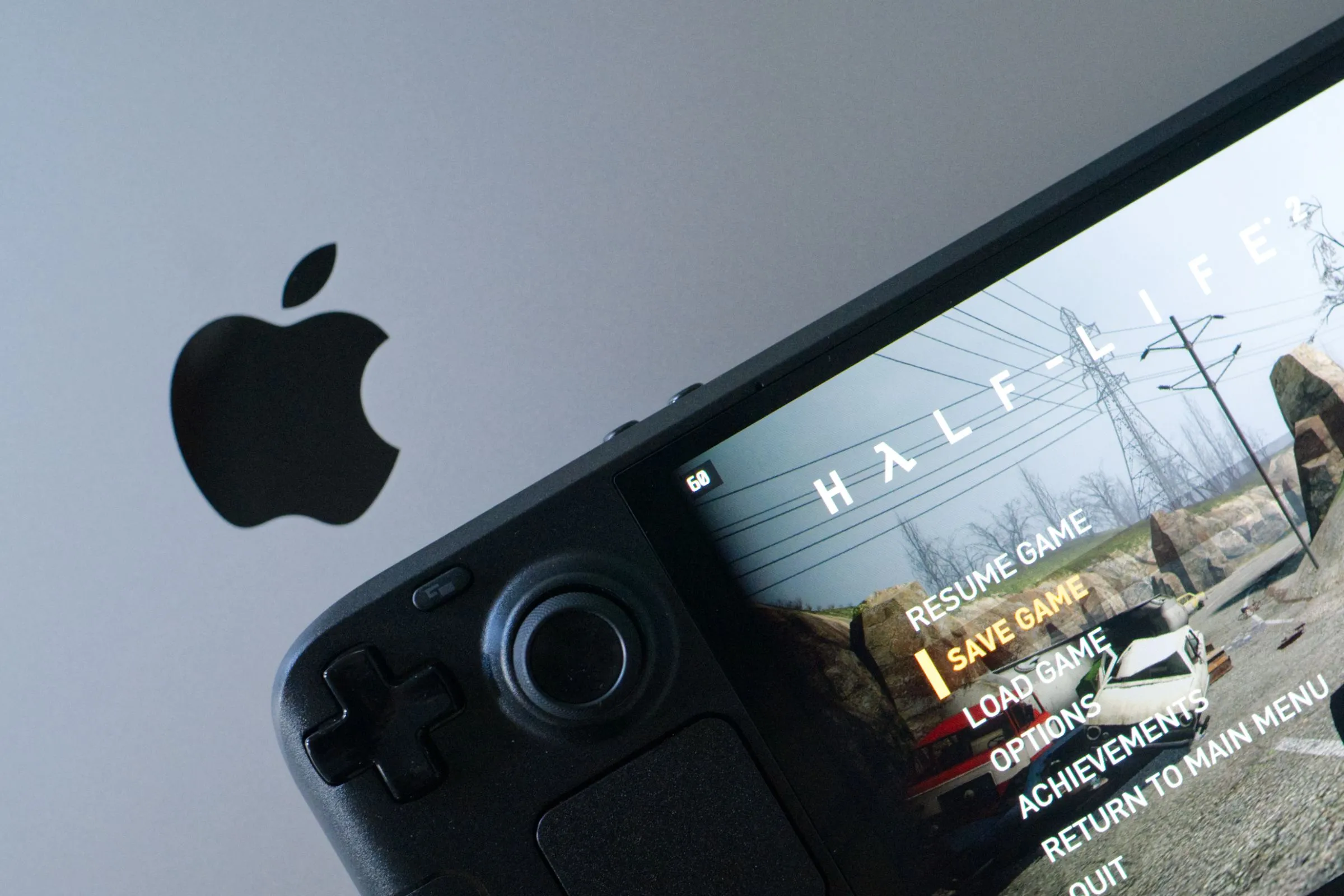 Màn hình Steam Deck OLED hiển thị game Half-Life 2, đặt trên MacBook Pro, cho thấy khả năng chơi game PC di động.