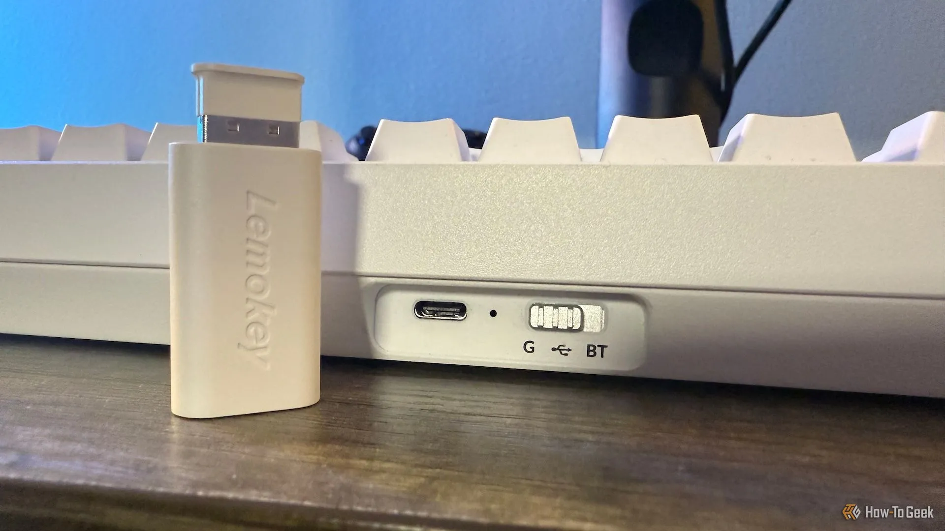 Mặt sau bàn phím Lemokey P1 HE với công tắc chuyển đổi chế độ kết nối và cổng cắm adapter 2.4 GHz, minh họa các tùy chọn không dây.