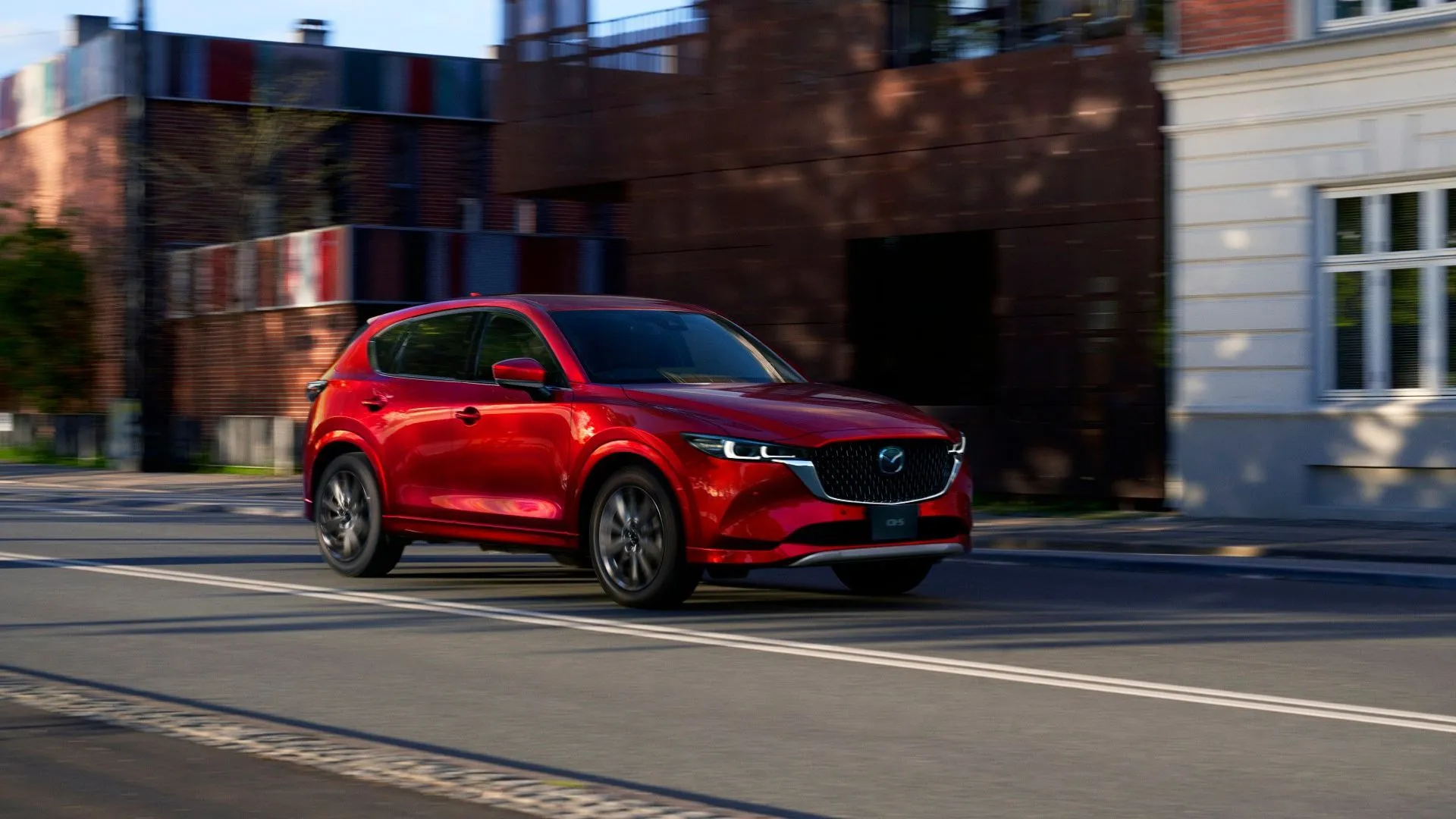 Mẫu SUV Mazda CX-5 đời 2025 màu đỏ đang di chuyển trên đường.