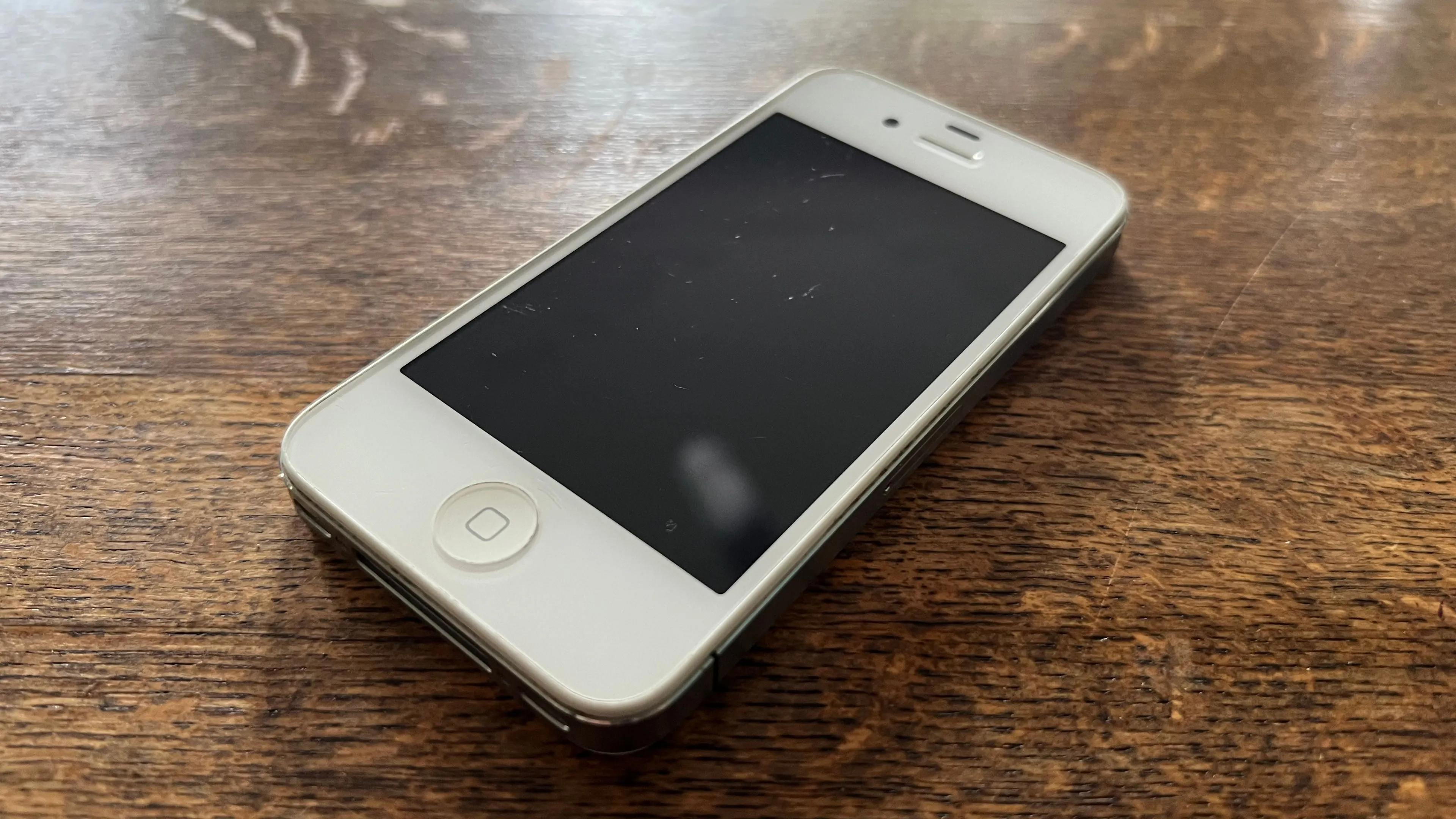 Một chiếc iPhone 4S màu trắng, đại diện cho những thiết bị điện tử cũ cần được tái chế đúng cách để bảo vệ môi trường.