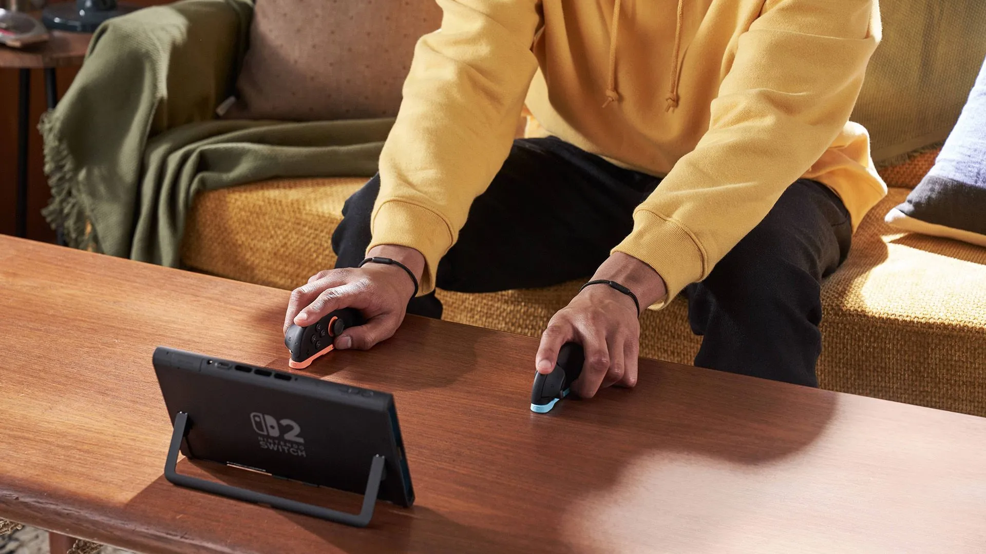 Một người đang chơi Nintendo Switch 2 với Joy-Cons tách rời, sử dụng chế độ &quot;dual mouse&quot;, thể hiện tính linh hoạt trong điều khiển.