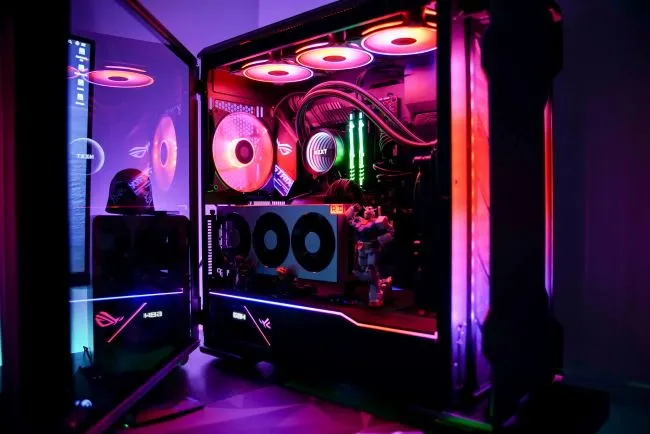 Nội thất máy tính chơi game với đèn LED RGB rực rỡ và bảng điều khiển bên mở, minh họa sự thỏa mãn khi tự build PC