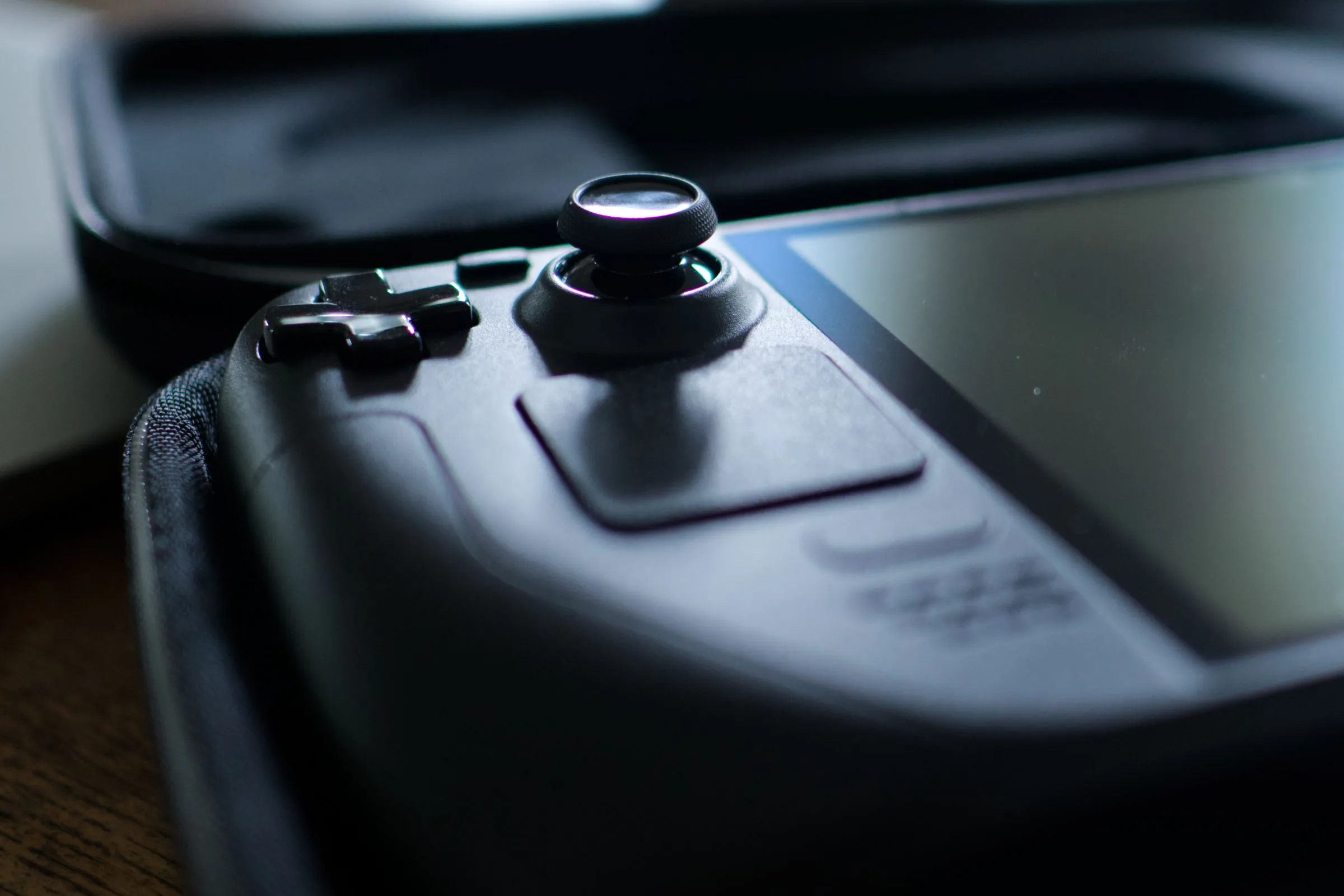 Steam Deck OLED trong hộp đựng với cần joystick trái đang được tập trung.