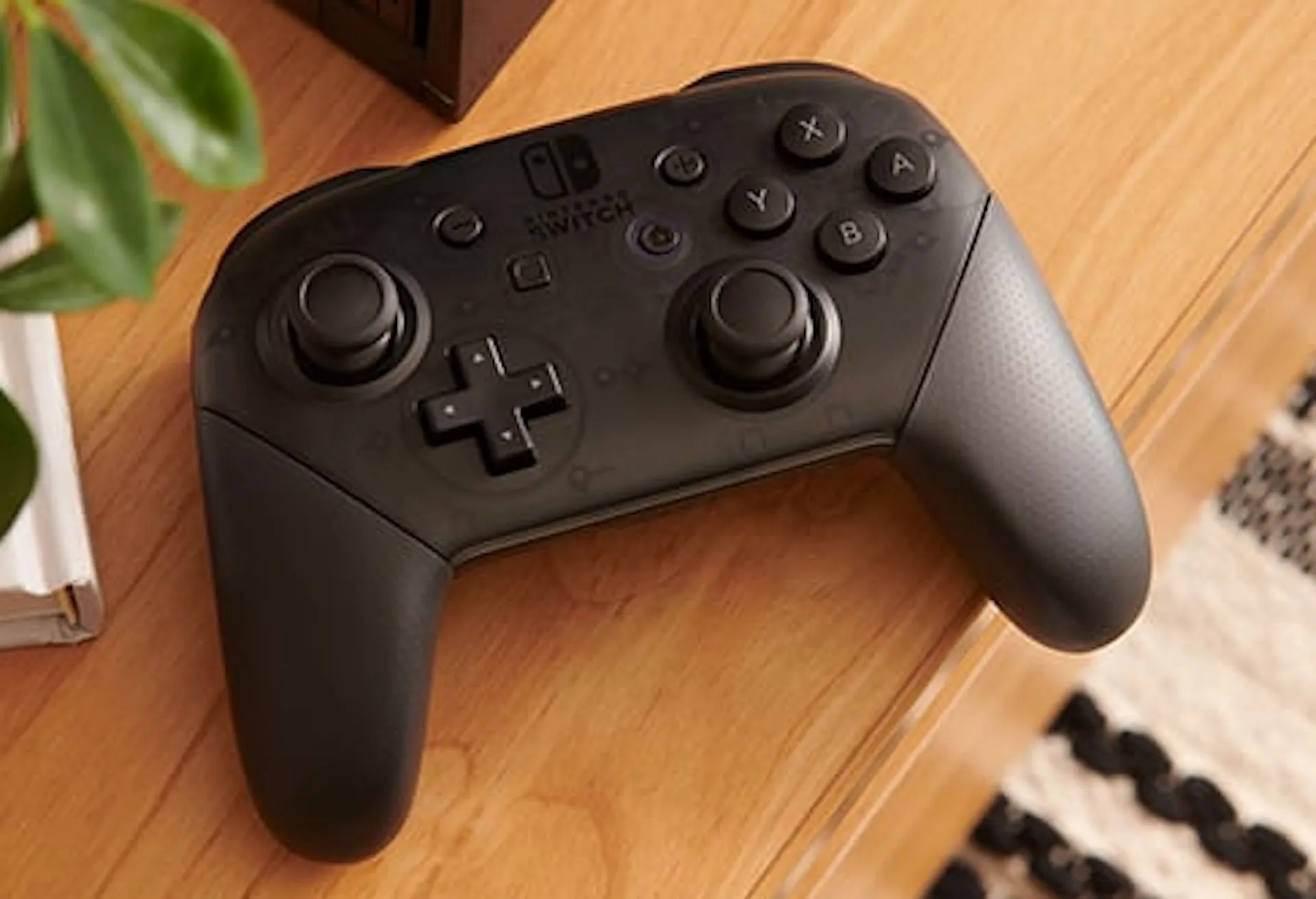 Tay cầm Nintendo Switch Pro Controller đặt trên bàn gỗ, gợi ý về thiết bị cần cập nhật firmware.