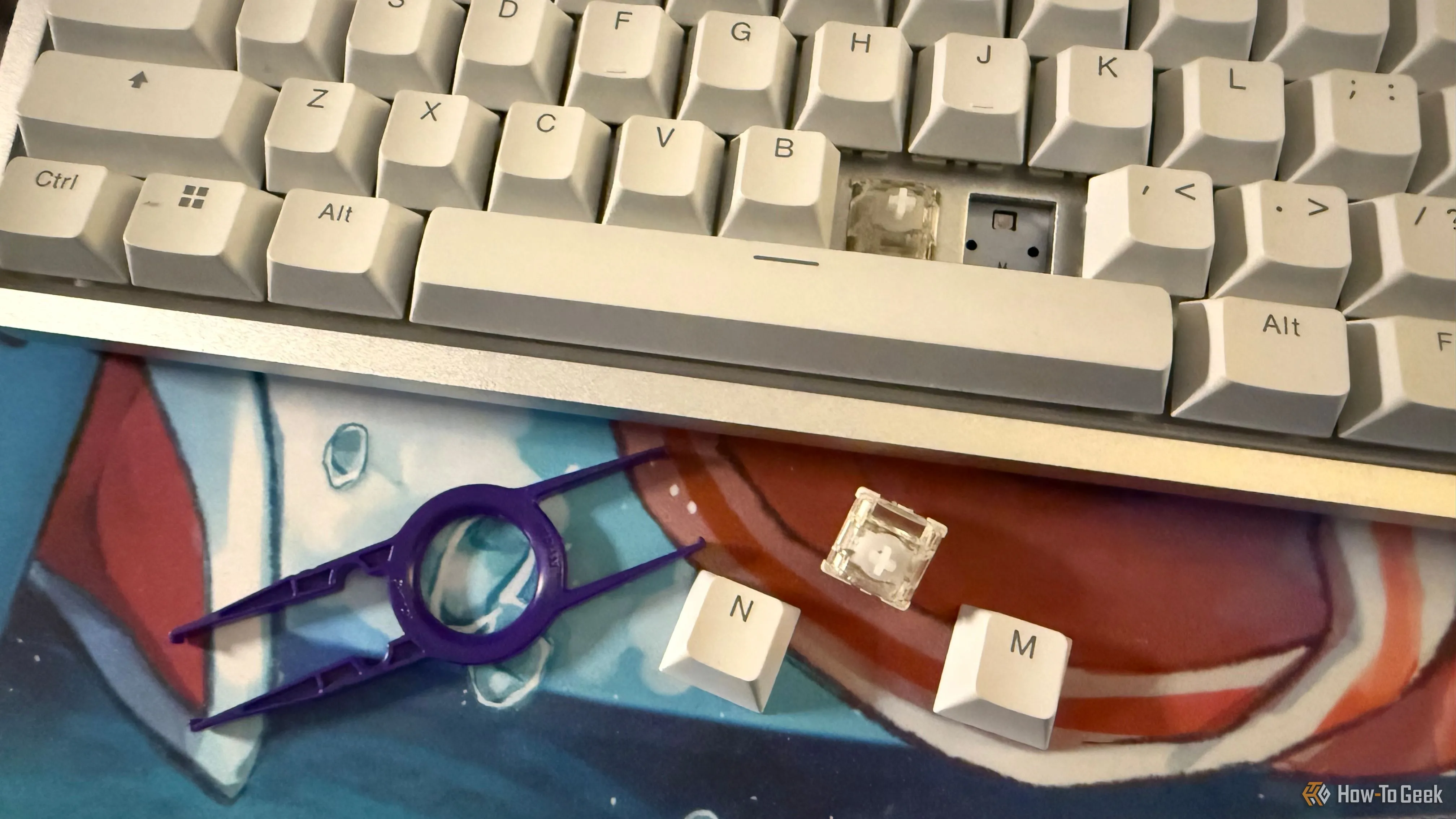 Bàn phím NZXT Function Elite MiniTKL với keycaps và switch từ tính đã tháo rời, cùng dụng cụ tháo