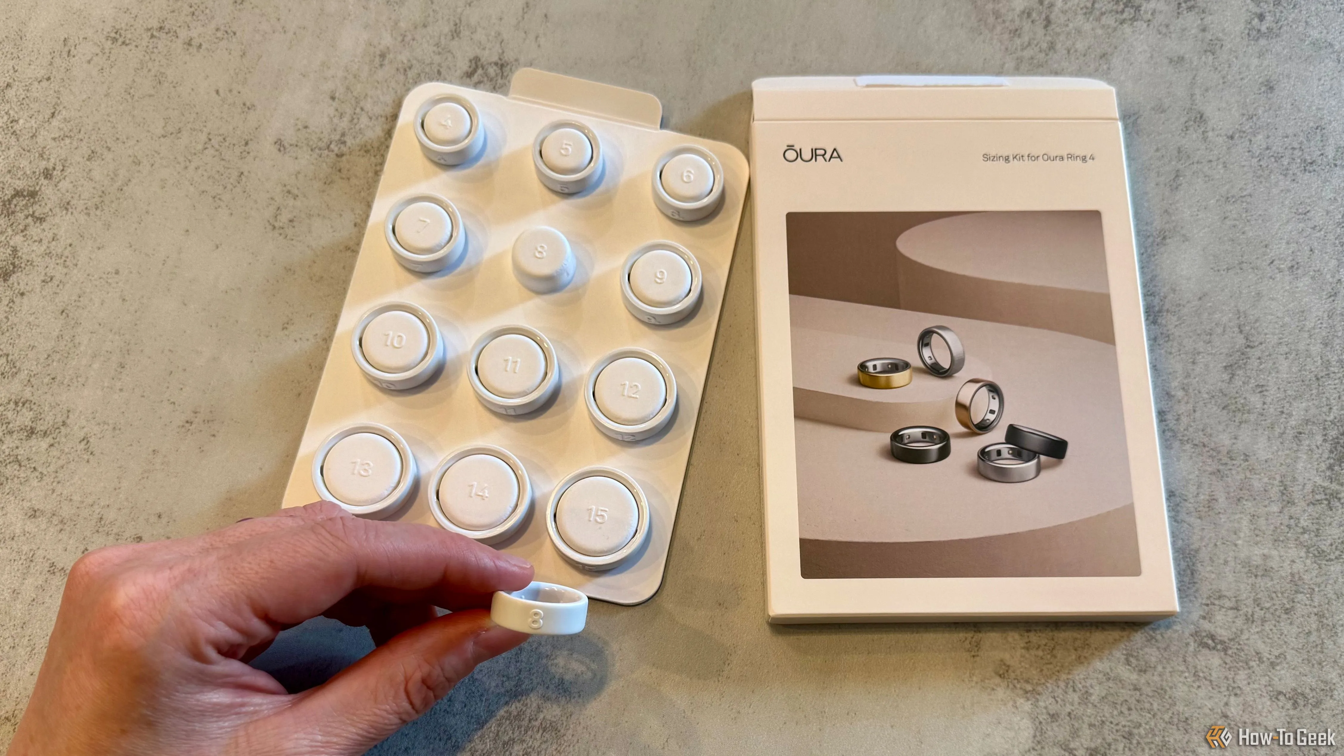 Bộ dụng cụ đo kích thước Oura Ring 4 với một chiếc nhẫn thử đang được cầm