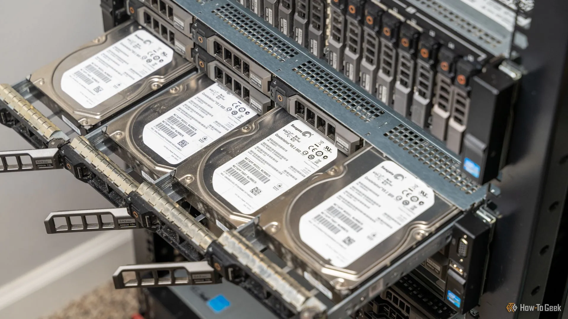 Bốn ổ cứng HDD nhô ra từ máy chủ rack-mount, minh họa giải pháp lưu trữ và sao lưu dữ liệu quan trọng.