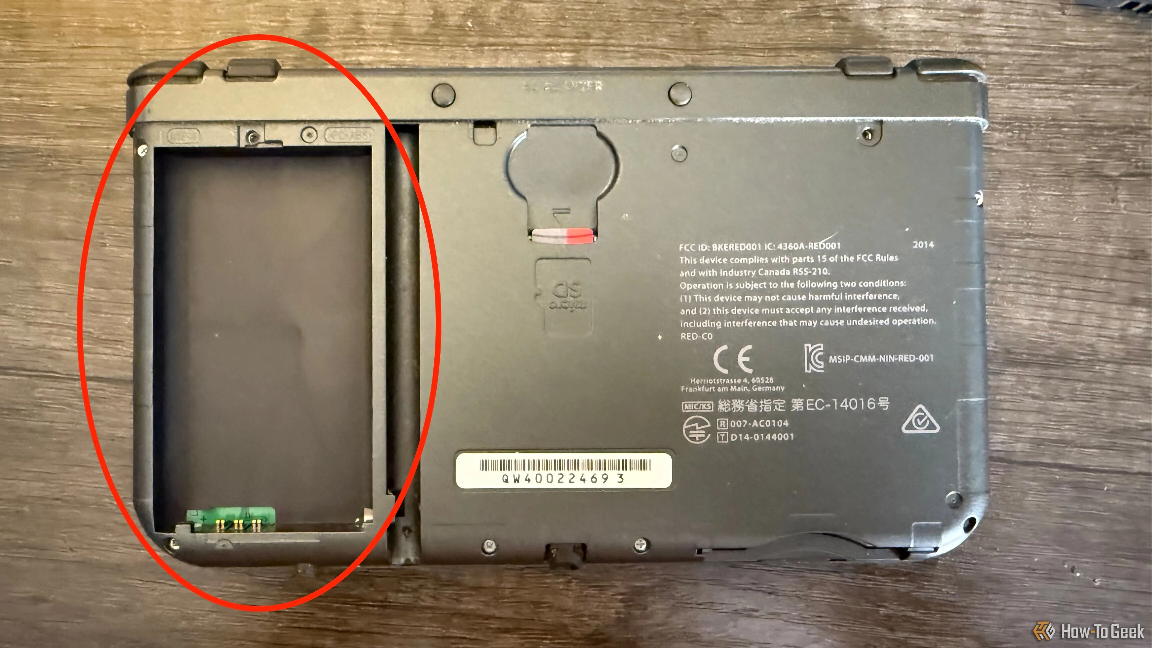 Cận cảnh mặt sau của New Nintendo 3DS XL với khe cắm thẻ microSD và khoang chứa pin rỗng, sẵn sàng lắp pin mới.