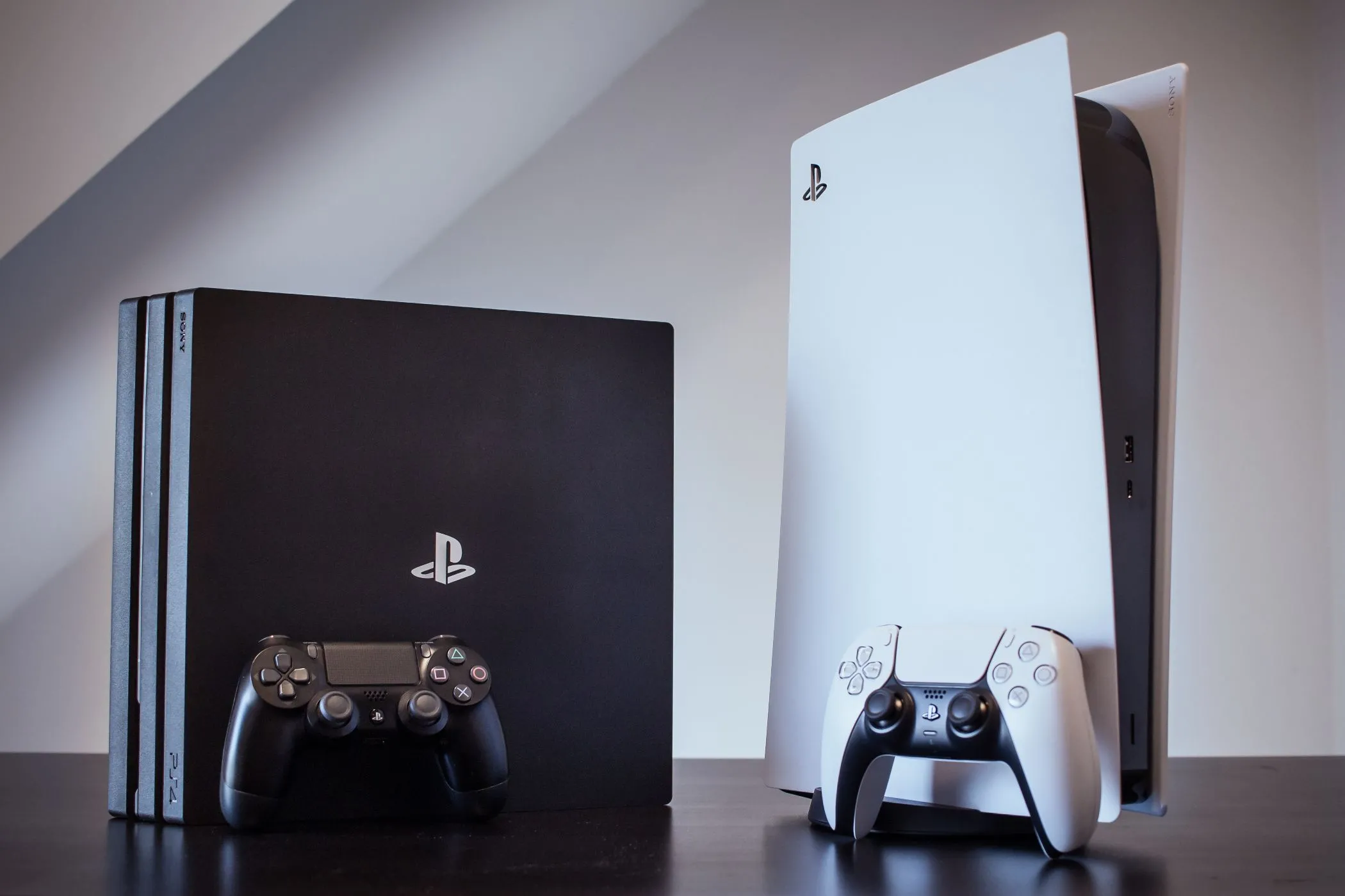 Hai máy console PS4 Pro và PS5 đặt cạnh nhau, minh họa sự khác biệt thế hệ