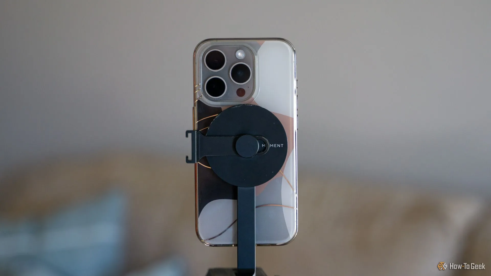 iPhone với ốp lưng MagSafe gắn chắc chắn vào giá đỡ tripod Moment MagSafe, đảm bảo an toàn.