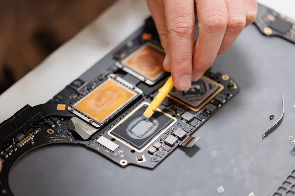 Kỹ thuật viên đang tỉ mỉ sửa chữa MacBook, nhấn mạnh chi phí lao động cao và chuyên môn cần thiết