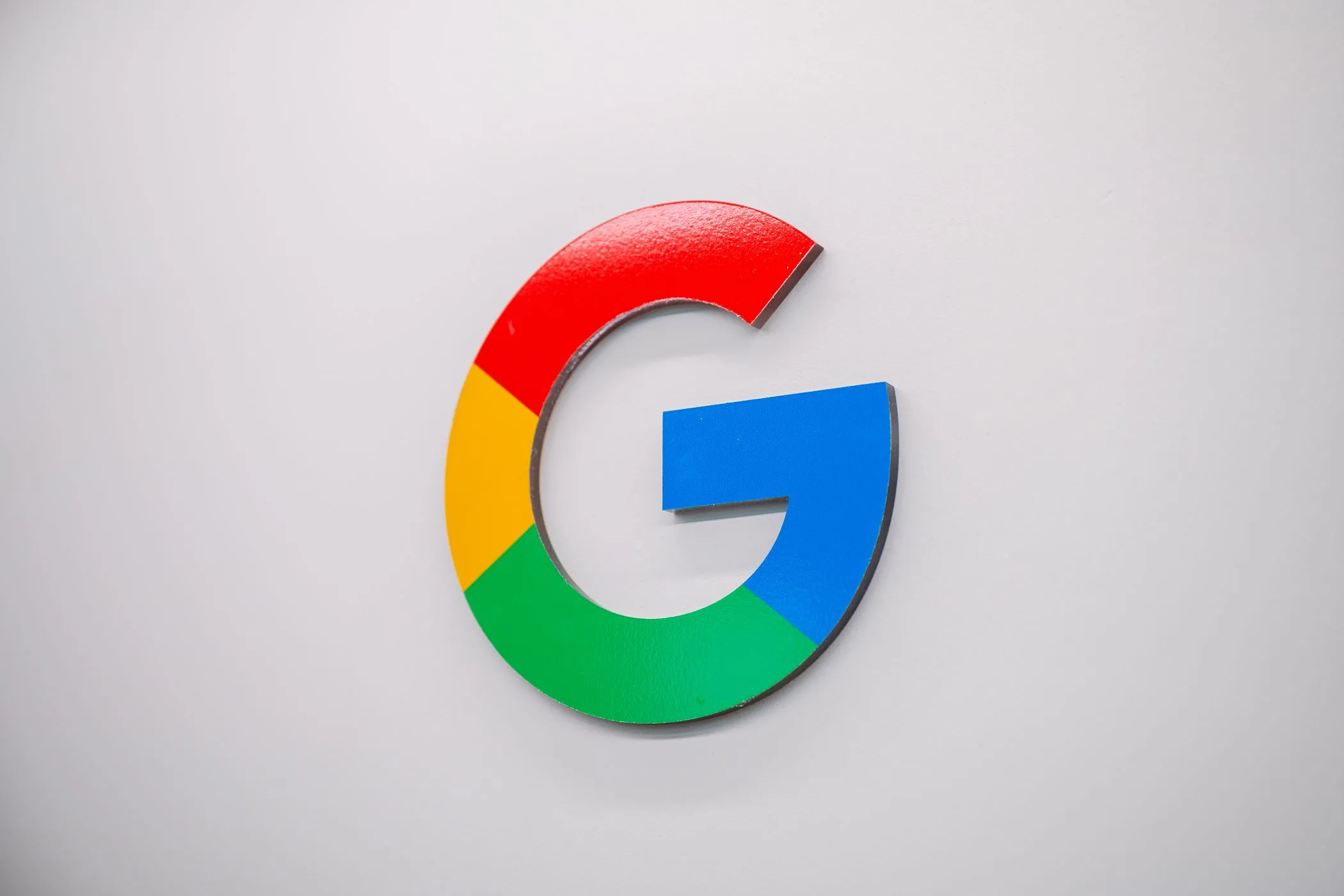 Logo Google trên tường, thể hiện cam kết của Google trong việc bảo vệ người dùng khỏi tin nhắn lừa đảo và tăng cường an ninh mạng.
