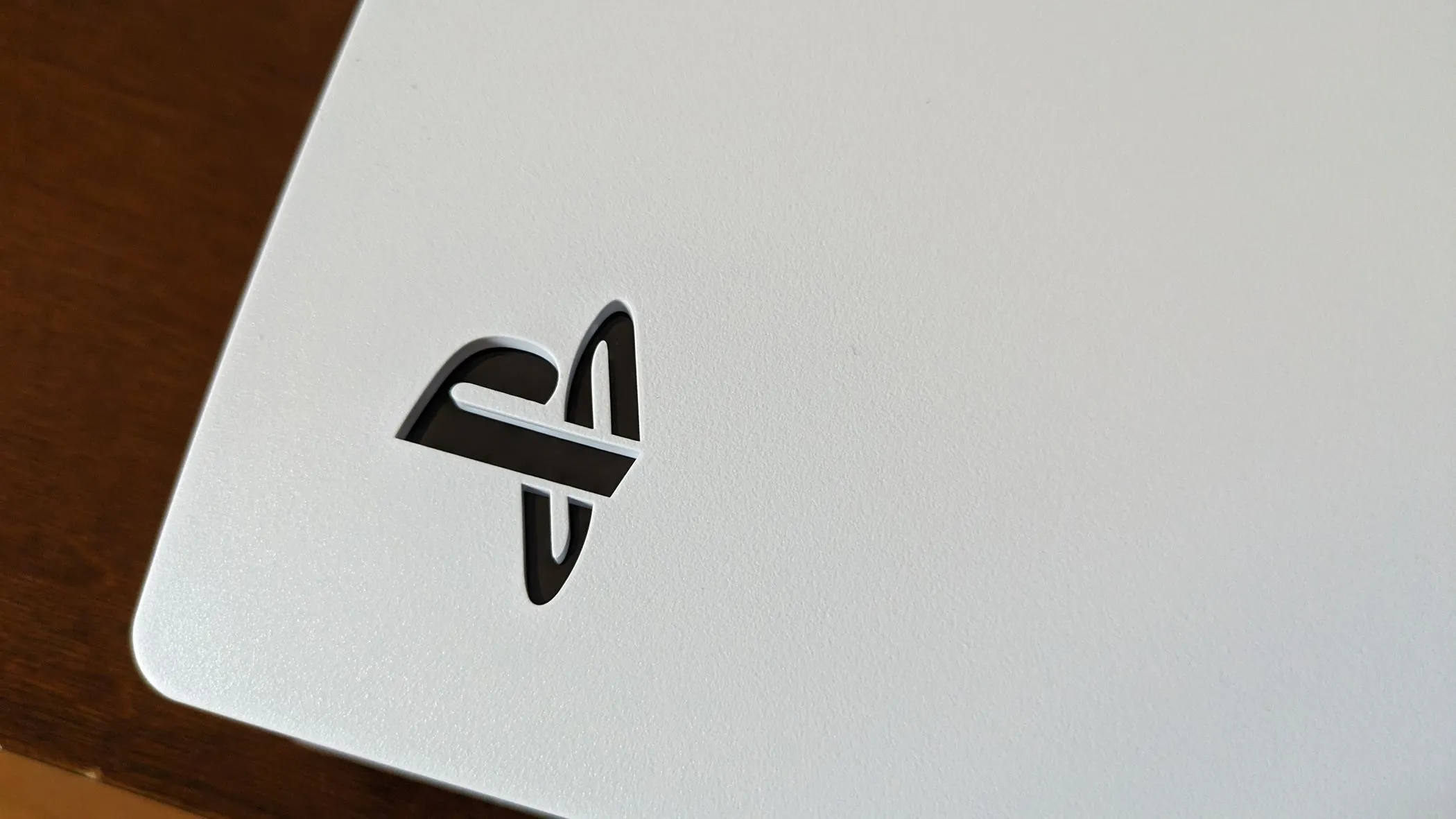 Logo PlayStation 5 sáng trên thân máy, đại diện cho console đối thủ và các dịch vụ game của Sony.