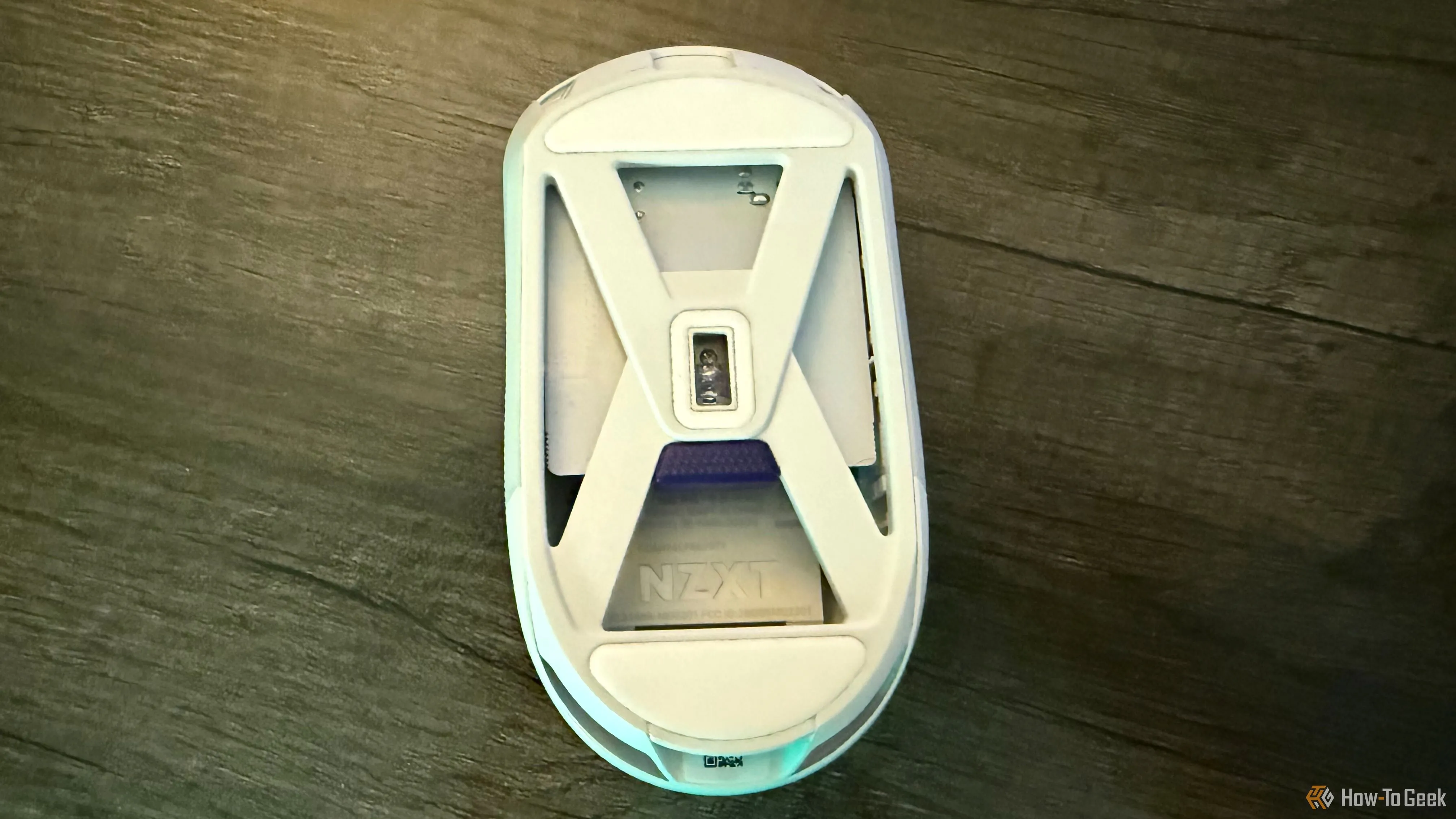 Mặt dưới của chuột NZXT Lift Elite Wireless màu đen, cho thấy nút chuyển đổi profile và cảm biến quang học.