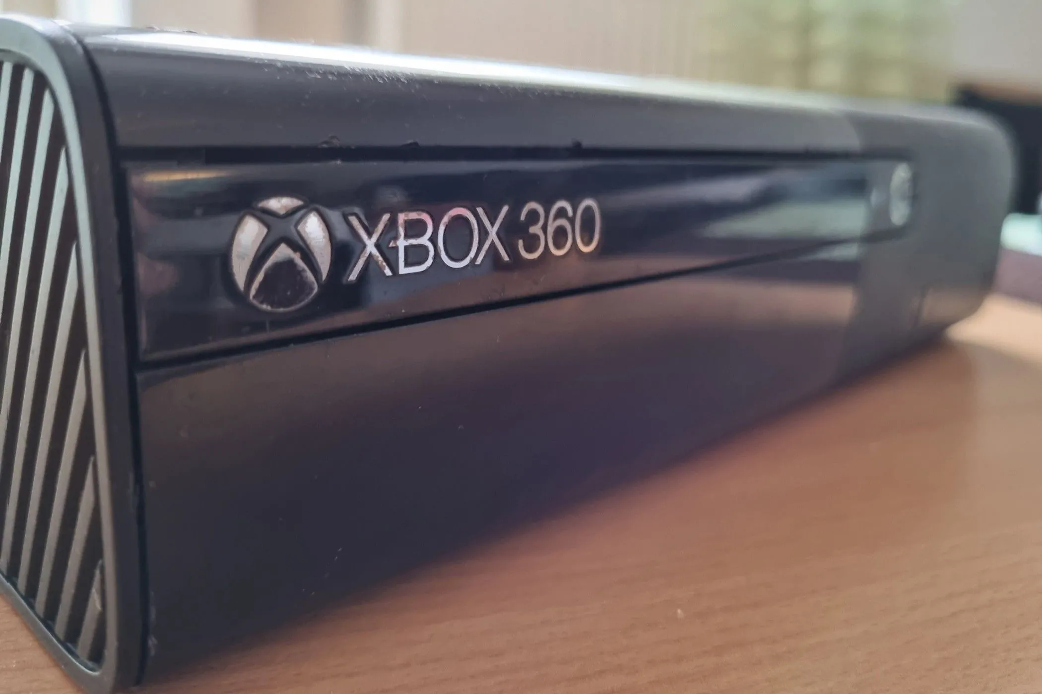 Máy chơi game Xbox 360 màu trắng cũ kỹ, minh họa việc Microsoft cập nhật phần mềm để quảng cáo
