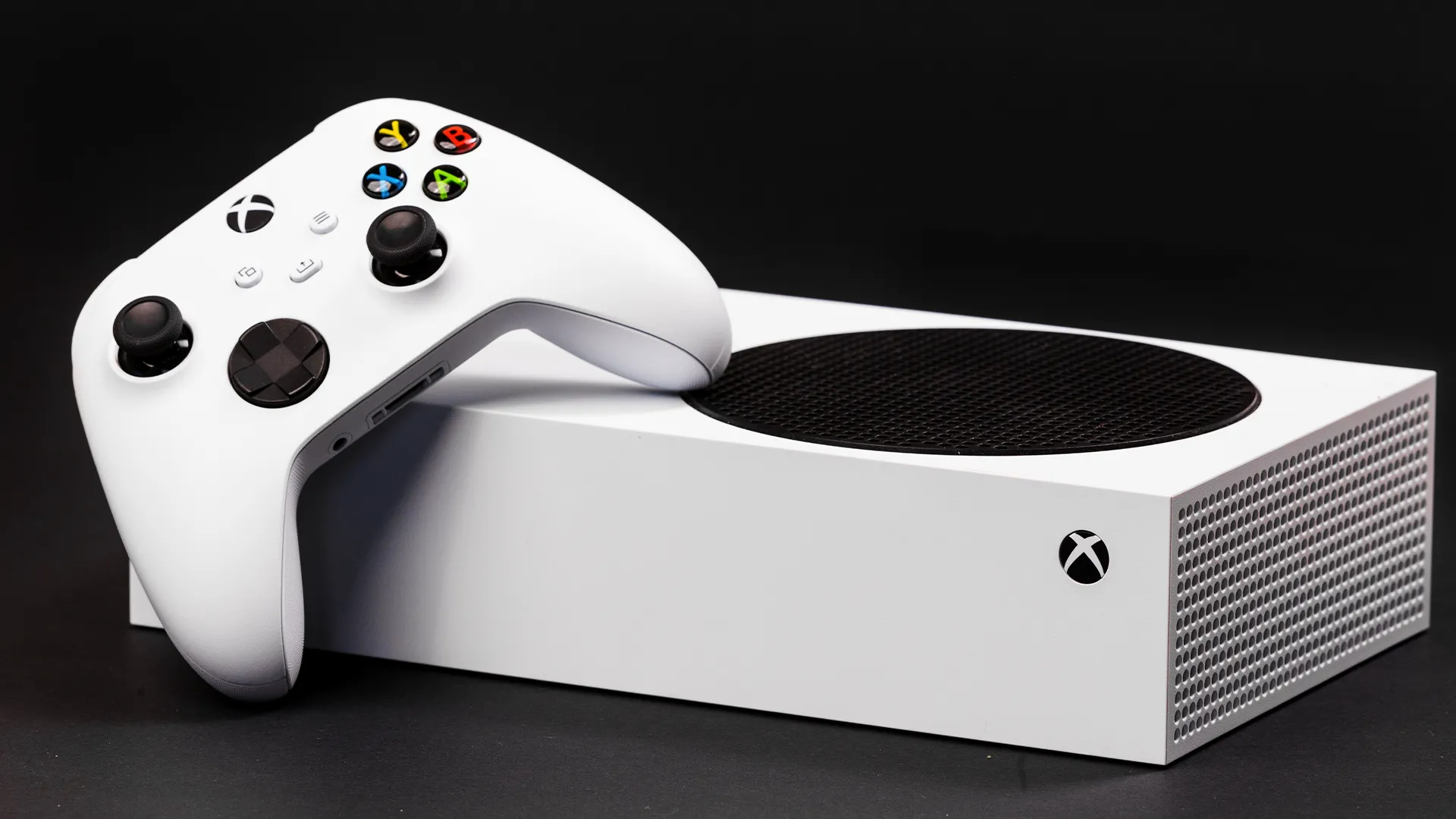 Máy chơi game Xbox Series S màu trắng đặt ngang cùng với tay cầm Xbox Series.