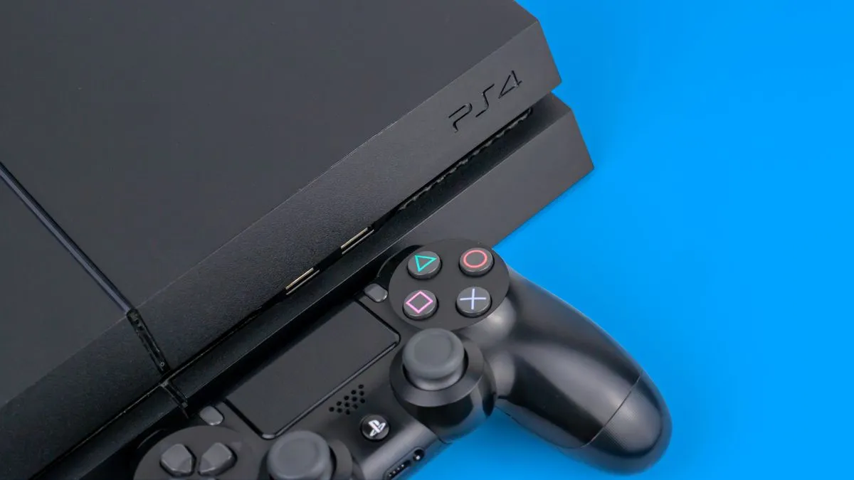 Máy PlayStation 4 màu đen cùng tay cầm DualShock trên nền xanh, thể hiện sự tối ưu về hiệu suất và trải nghiệm người dùng.