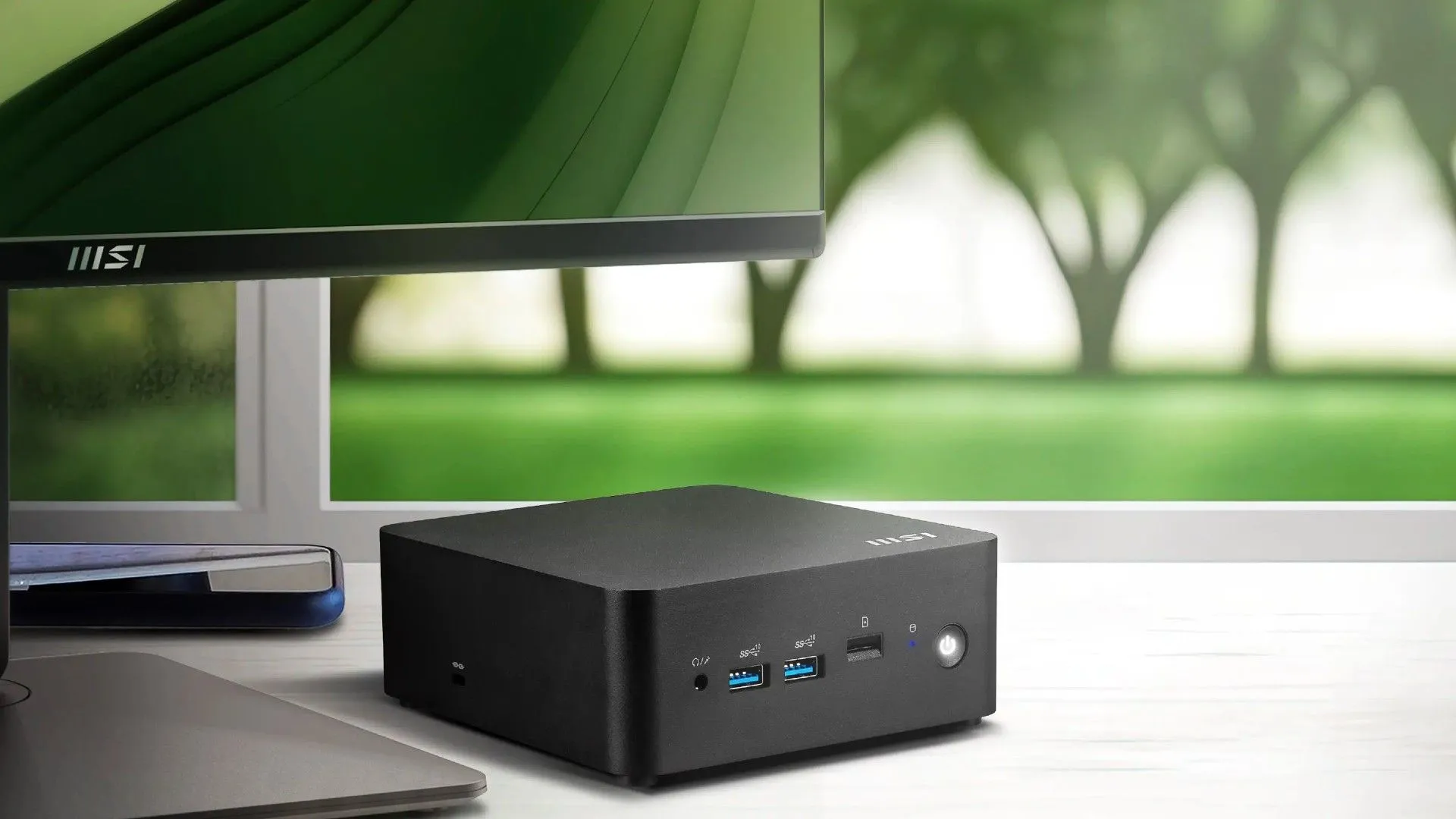 Máy tính mini MSI Cubi NUC AI Series đặt cạnh màn hình, đại diện cho dòng PC nhỏ gọn tích hợp AI