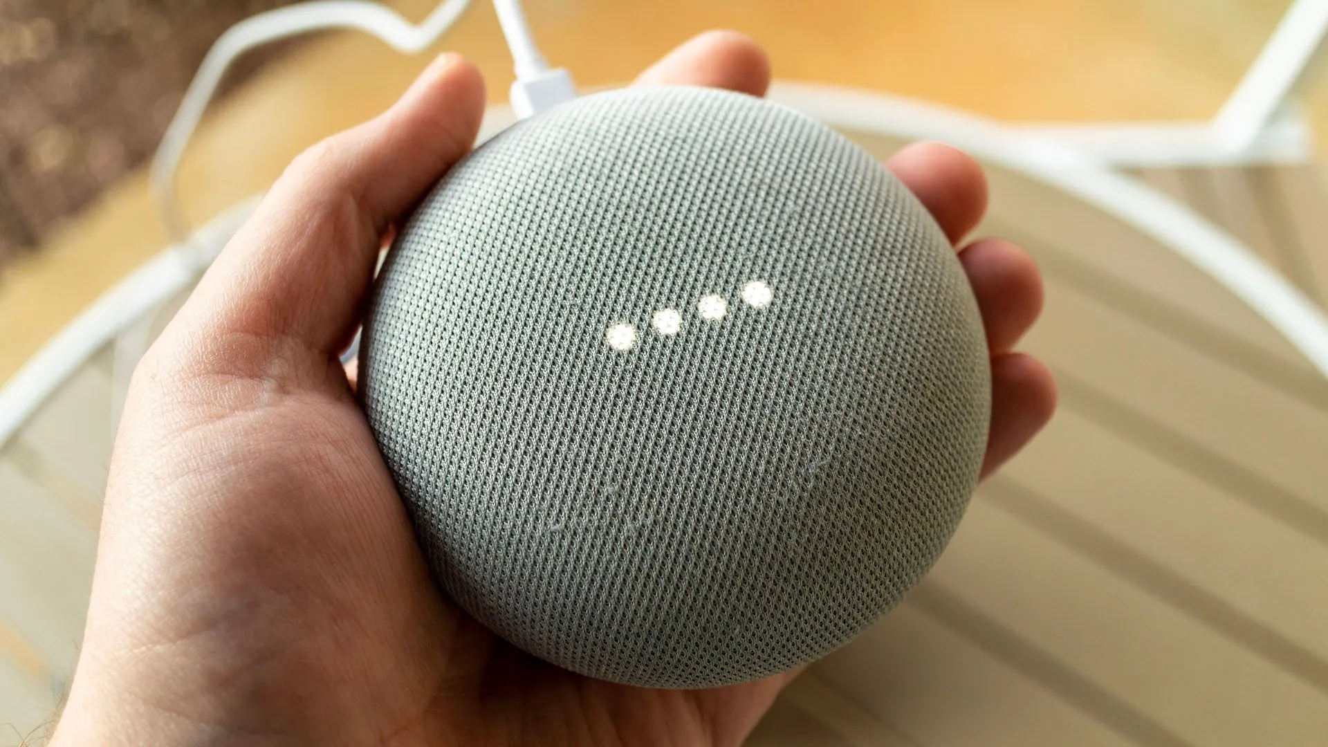 Một bàn tay đang cầm loa Google Nest, thể hiện khả năng tích hợp Home Assistant với Google Assistant và các thiết bị Google Home.