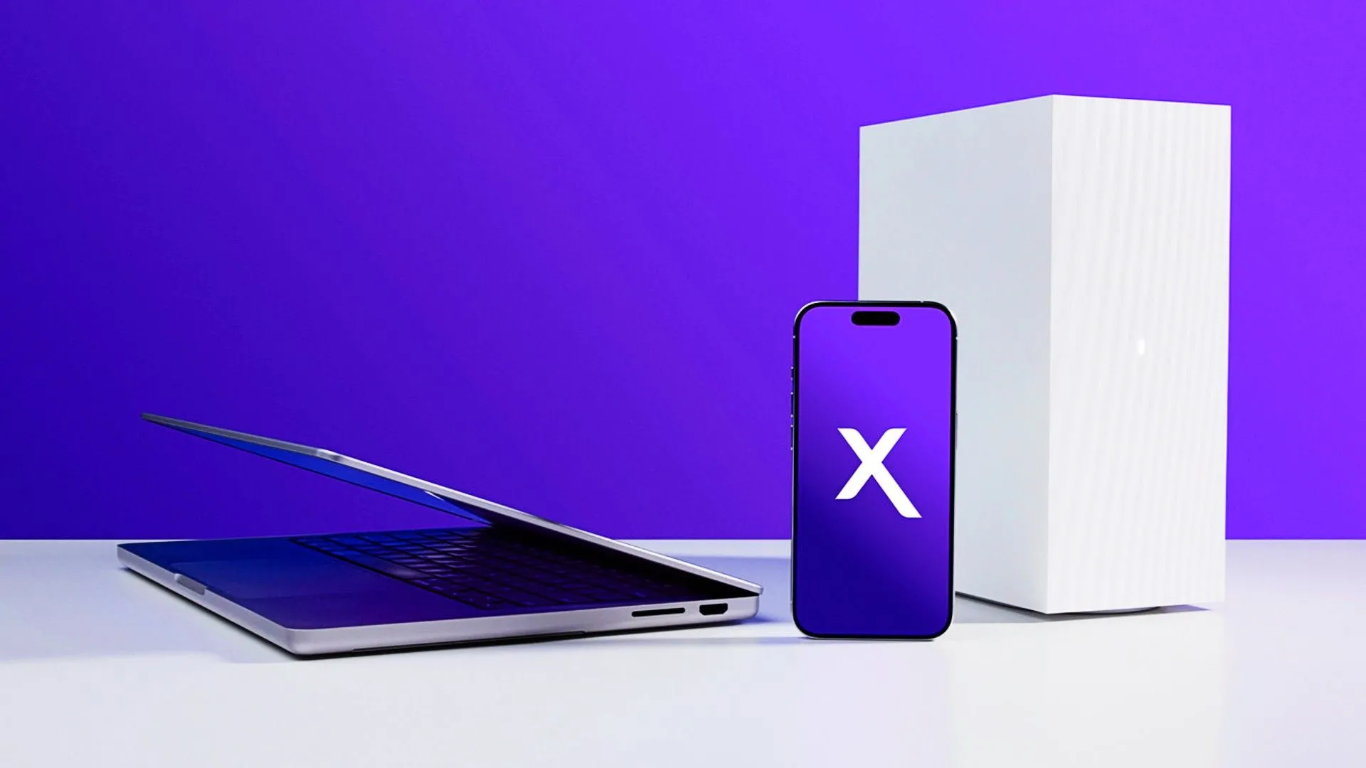 Một chiếc laptop, điện thoại và case PC đặt trên bàn trắng, minh họa dịch vụ internet Xfinity