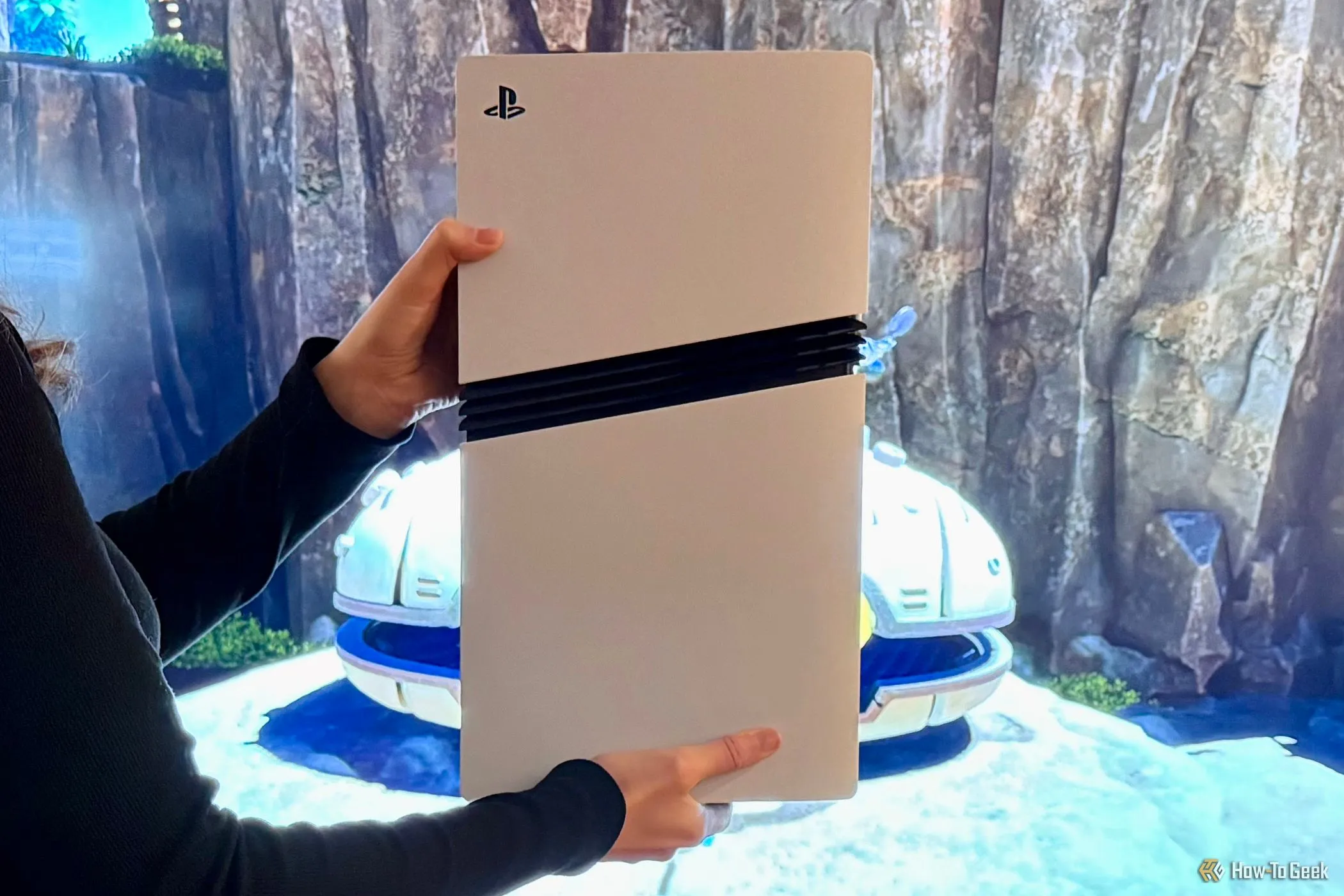 Một người chơi đang cầm PlayStation 5 Pro trước màn hình TV lớn, tận hưởng trải nghiệm chơi game nhập vai