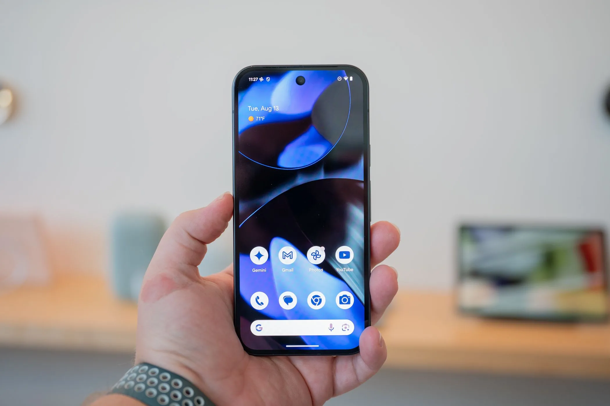 Một người đang cầm Google Pixel 9 hiển thị màn hình, tượng trưng cho trải nghiệm Android thuần túy và thiết kế tối giản