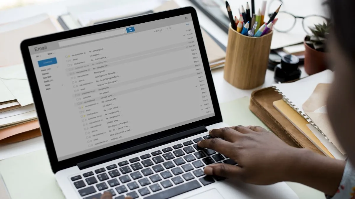 Một người phụ nữ tập trung kiểm tra email trên máy tính xách tay, minh họa việc quản lý email theo lịch trình.