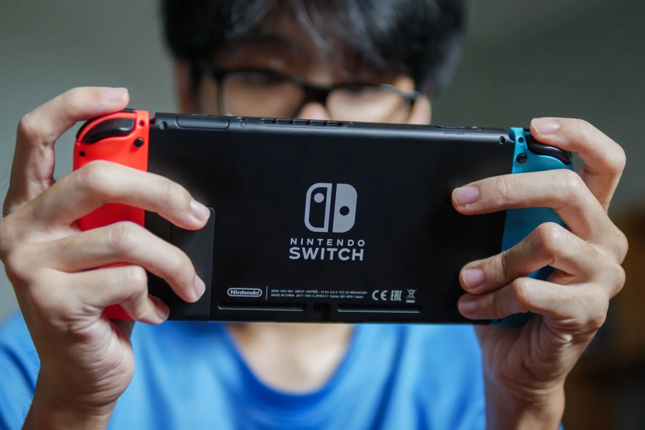 Người đàn ông đang chơi game trên máy Nintendo Switch 2 ở chế độ cầm tay, thể hiện tính linh hoạt