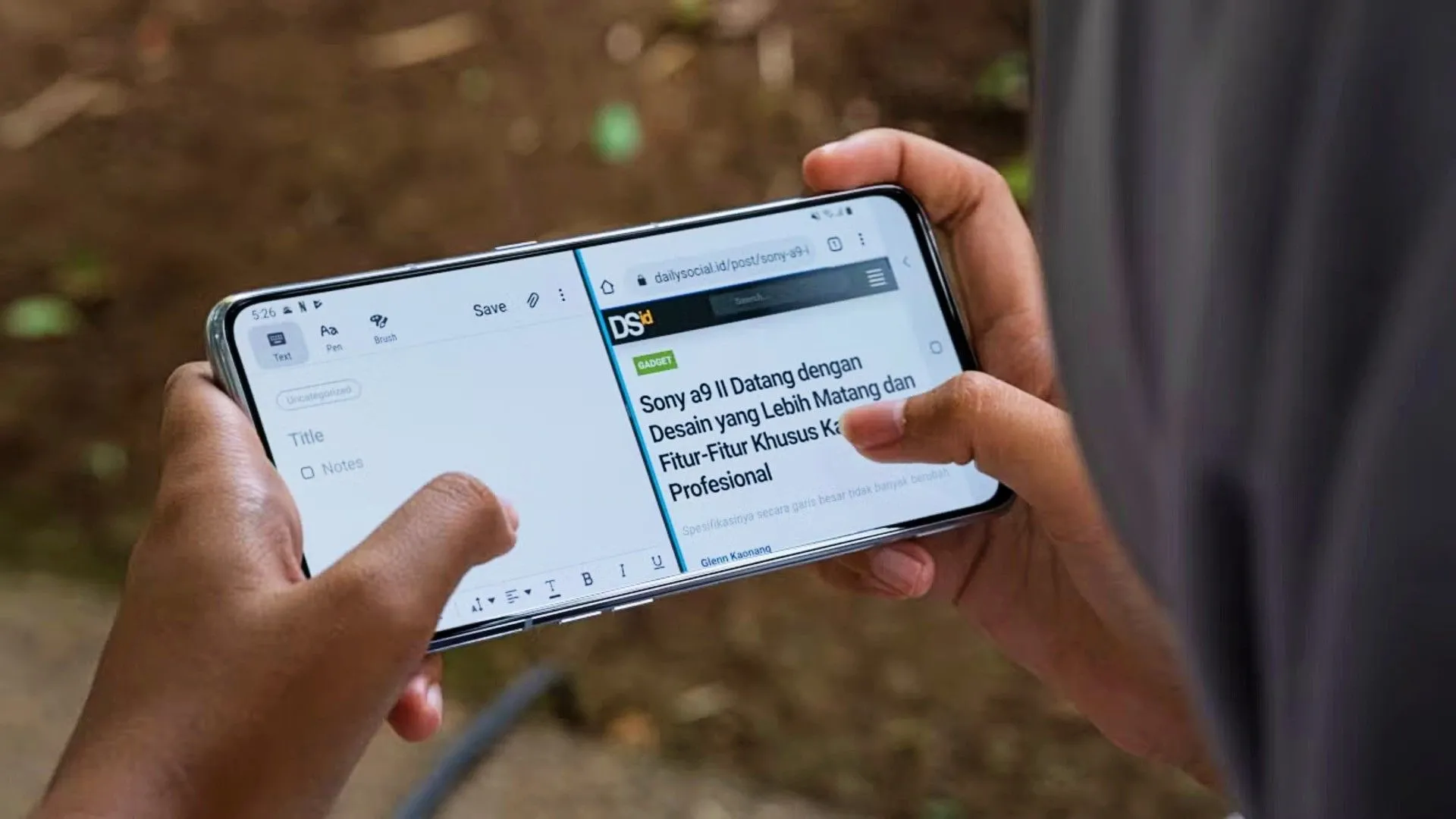 Người đang cầm điện thoại Android và sử dụng chế độ chia đôi màn hình