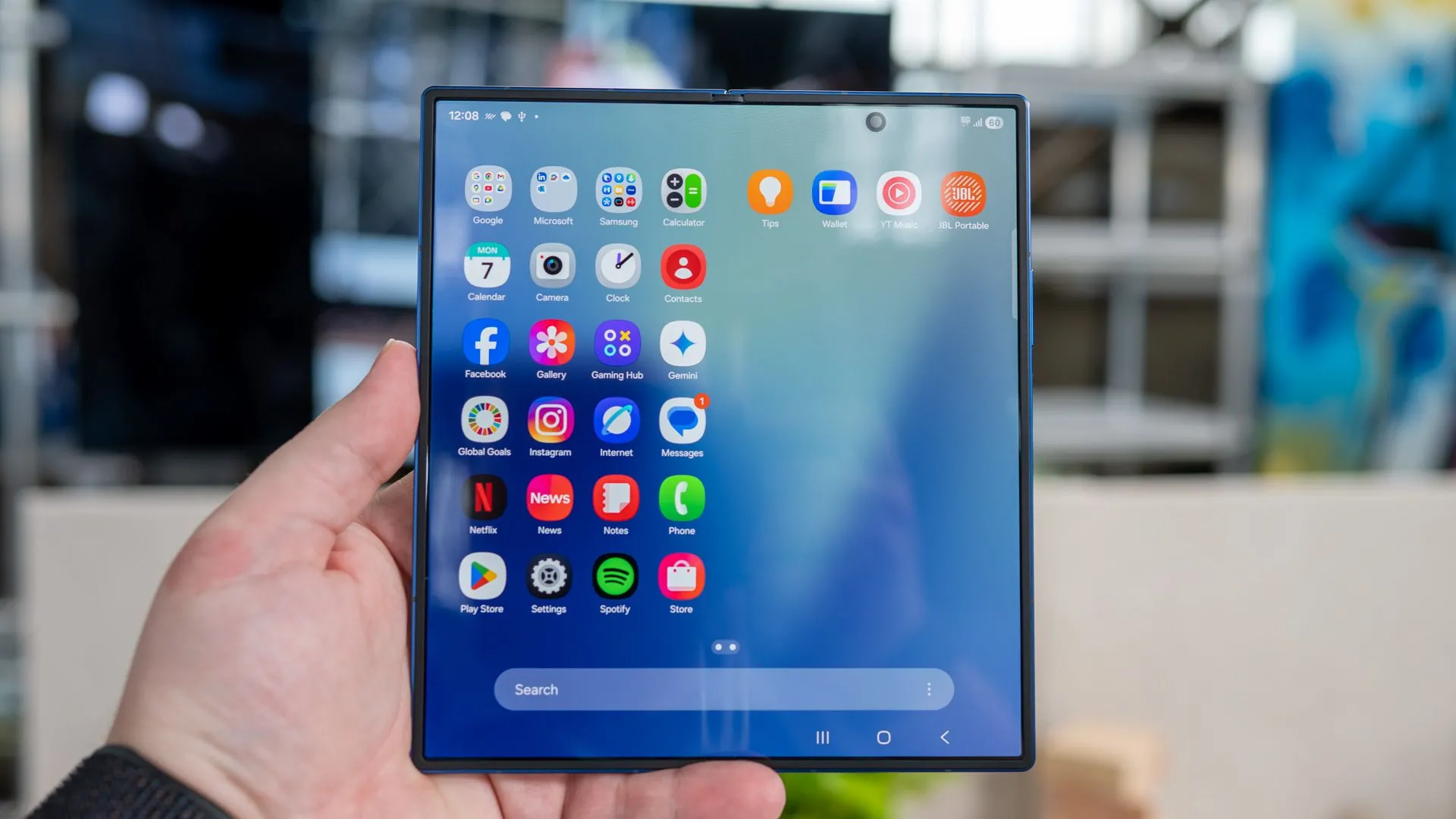 Người dùng cầm Samsung Galaxy Z Fold 7 đang mở, hiển thị ngăn kéo ứng dụng và camera đục lỗ trên màn hình chính
