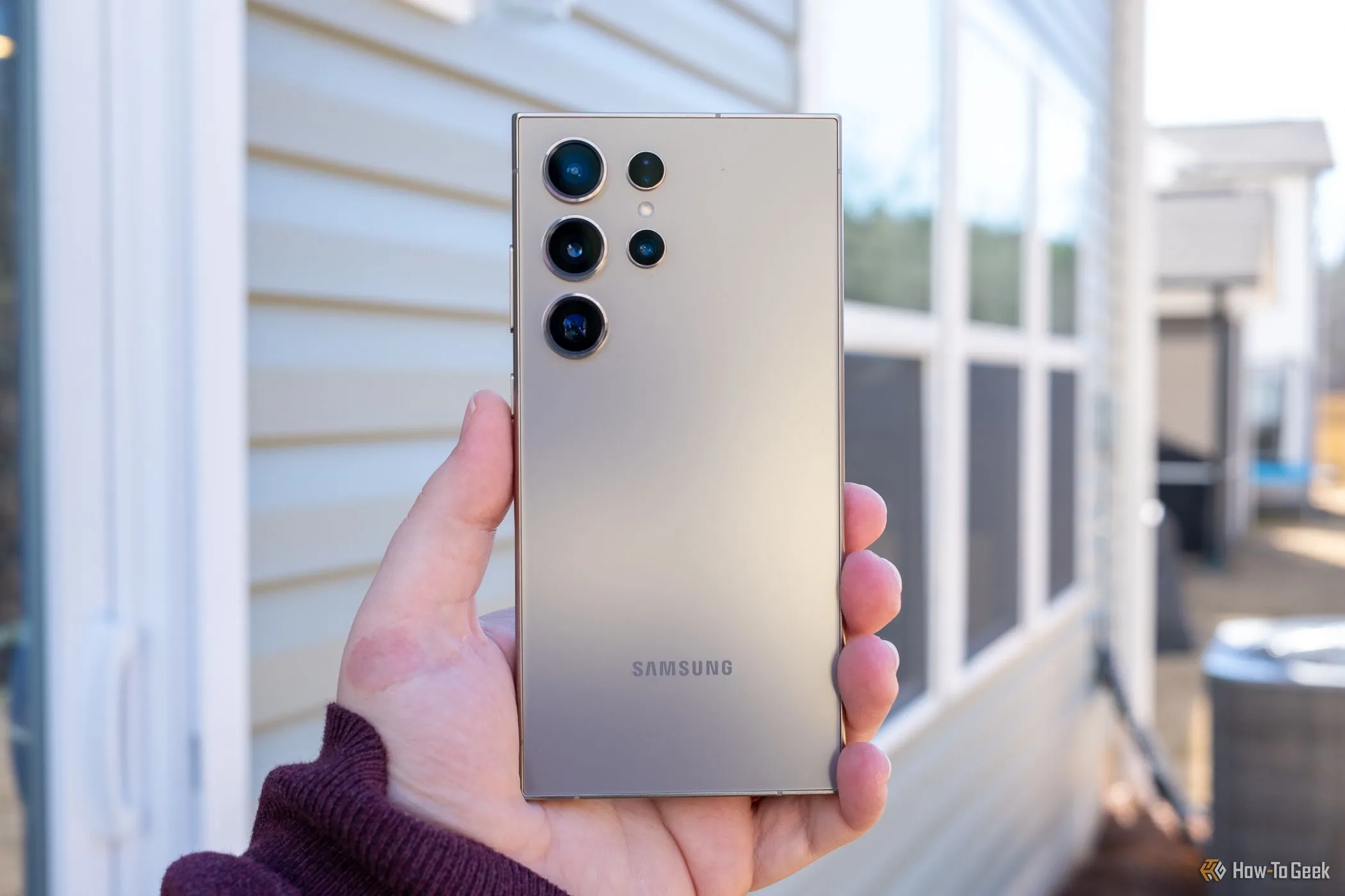 Người dùng đang cầm điện thoại Samsung Galaxy S24 Ultra ở mặt sau, minh họa cho chương trình điện thoại &quot;Certified Re-newed&quot;