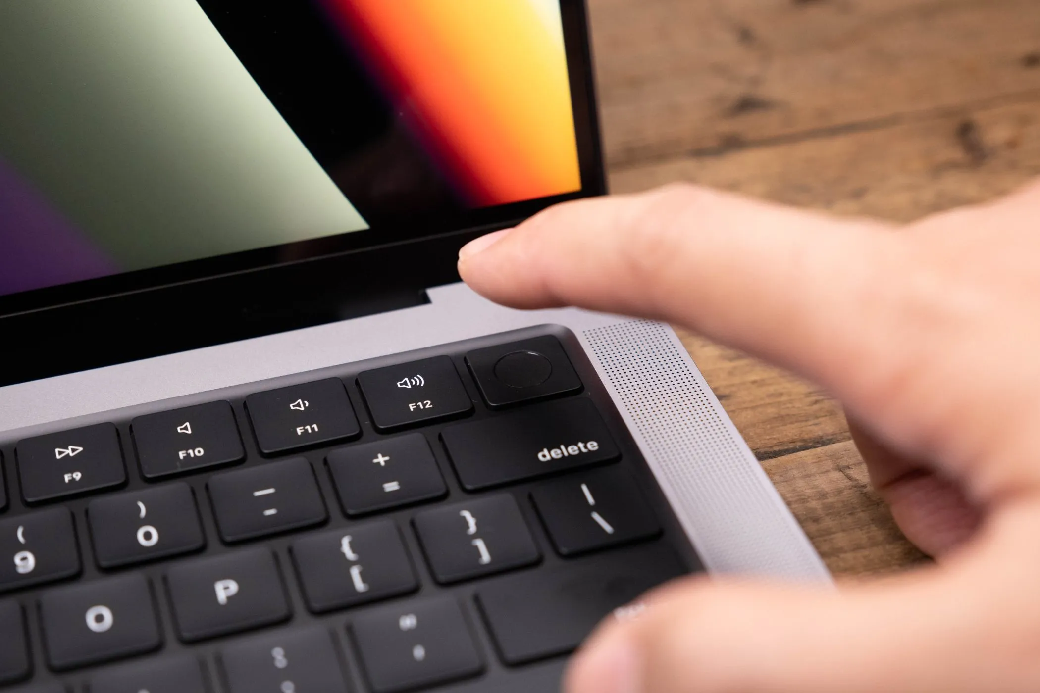 Người dùng đang xác thực bằng Touch ID trên MacBook, biểu tượng cho các linh kiện có khóa phần mềm và ghép nối số serial