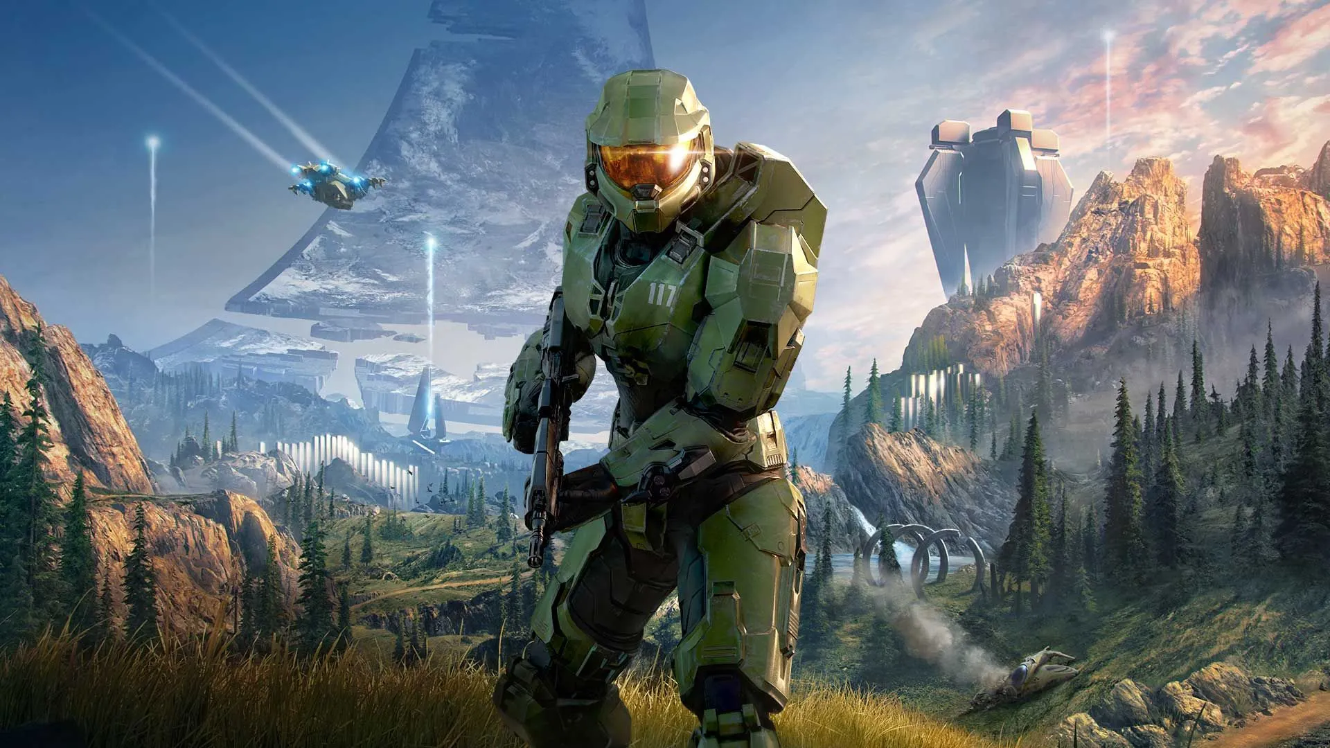 Nhân vật Master Chief đang cầm vũ khí trong khu vực rừng cây và cỏ trên chiếc vòng trong game Halo Infinite.