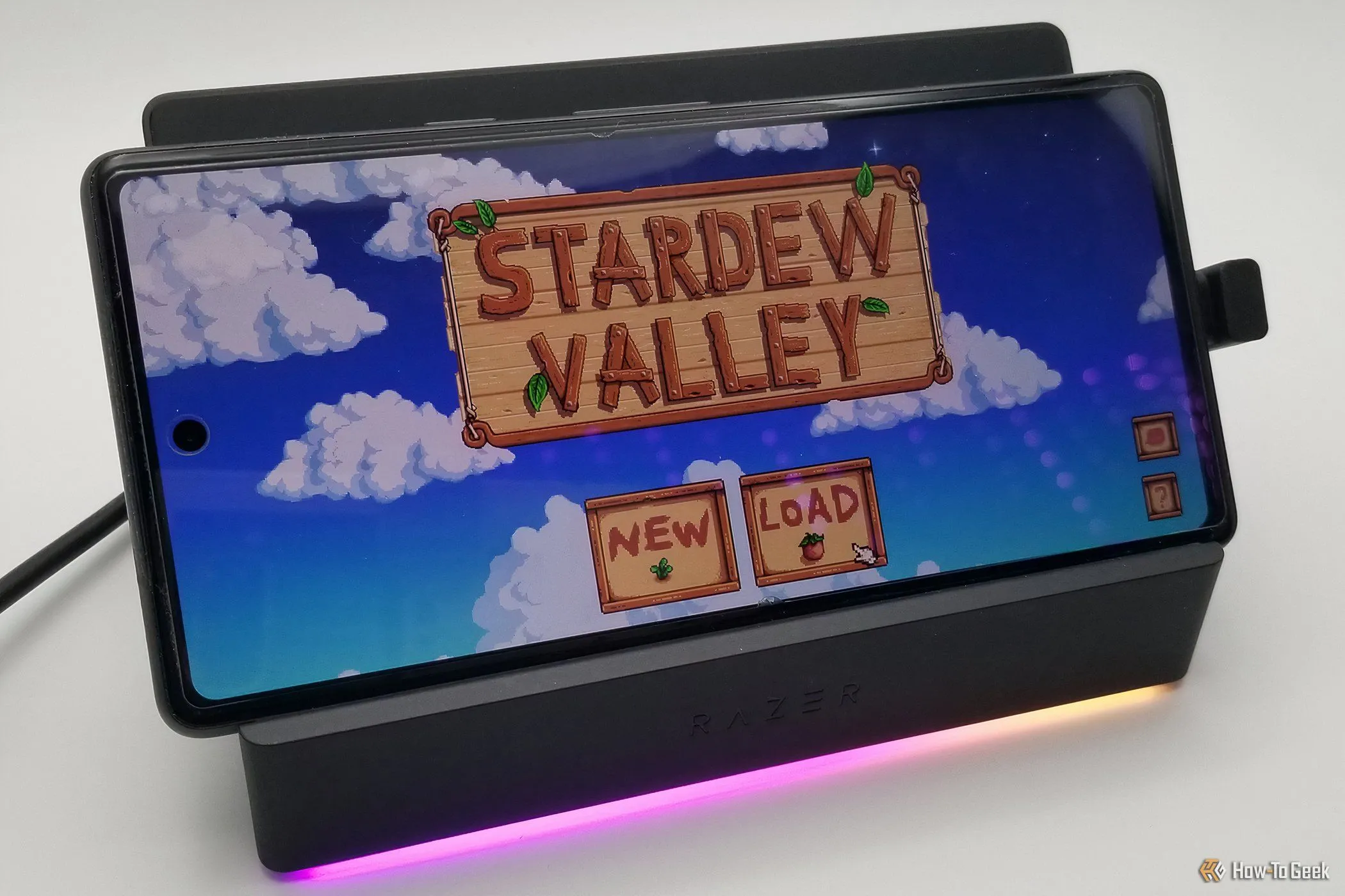 Razer Handheld Dock Chroma đang sạc và trưng bày một chiếc điện thoại thông minh chơi game di động