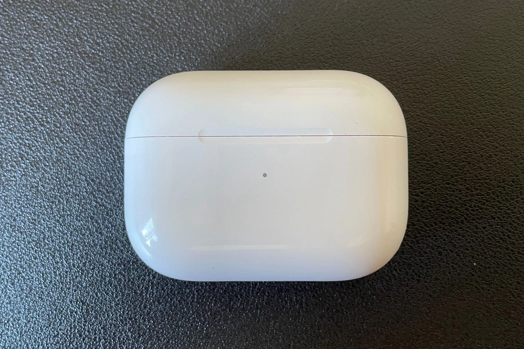 Tai nghe AirPods Pro trong hộp sạc đặt trên nền đen.