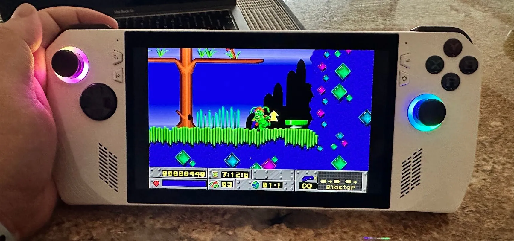 Thỏ Jazz Jackrabbit đang bắn súng trong một cảnh hành động trên màn hình của thiết bị chơi game cầm tay ROG Ally, với đồ họa rực rỡ và hiệu ứng cháy nổ.