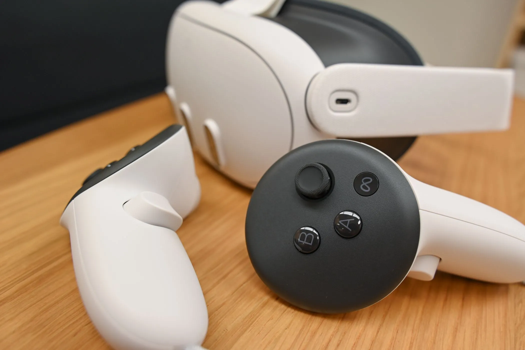 Kính thực tế ảo Meta Quest 3 màu trắng và hai bộ điều khiển Meta Quest Touch Plus màu trắng, đặt trên bàn làm việc