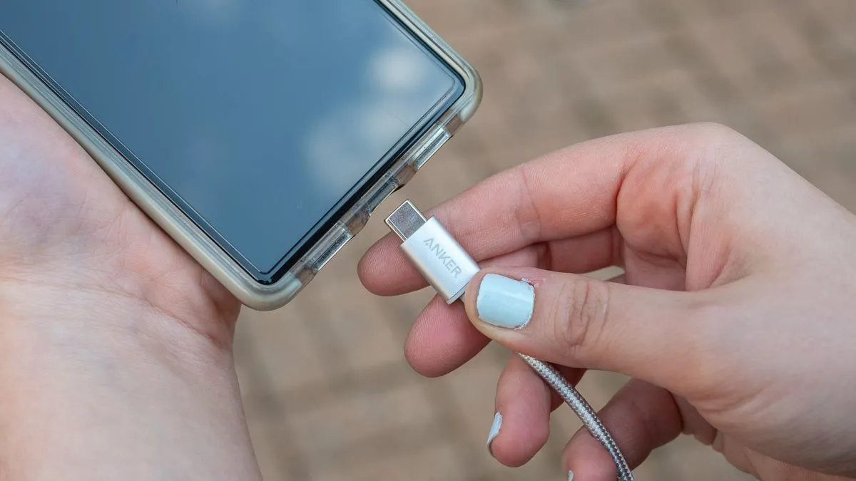 Người dùng cắm cáp USB-C bện nylon của Anker vào điện thoại, minh họa sự tiện lợi và tính phổ quát của cổng kết nối USB-C trong công nghệ.