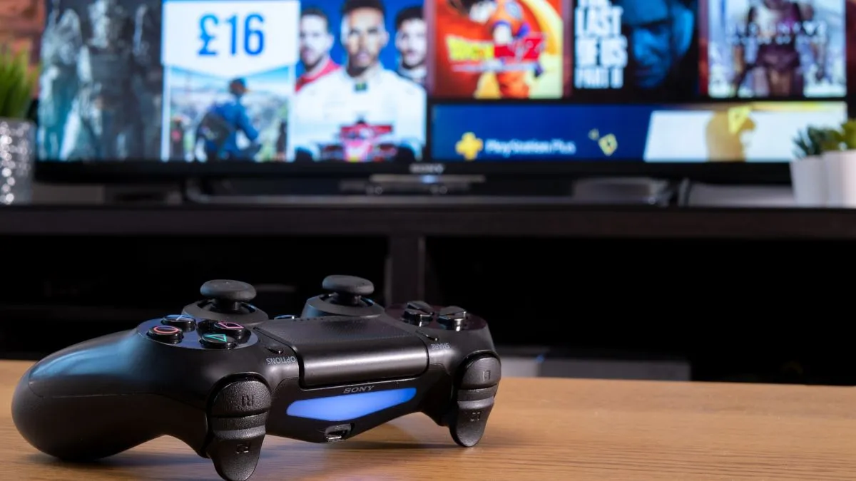 Tay cầm Sony Dualshock 4 trước màn hình TV hiển thị cửa hàng PlayStation, biểu trưng cho xu hướng số hóa toàn diện trong ngành game.