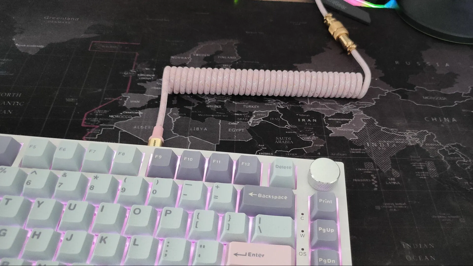 Cáp xoắn bàn phím màu hồng cắm vào bàn phím trắng với keycap xanh và tím