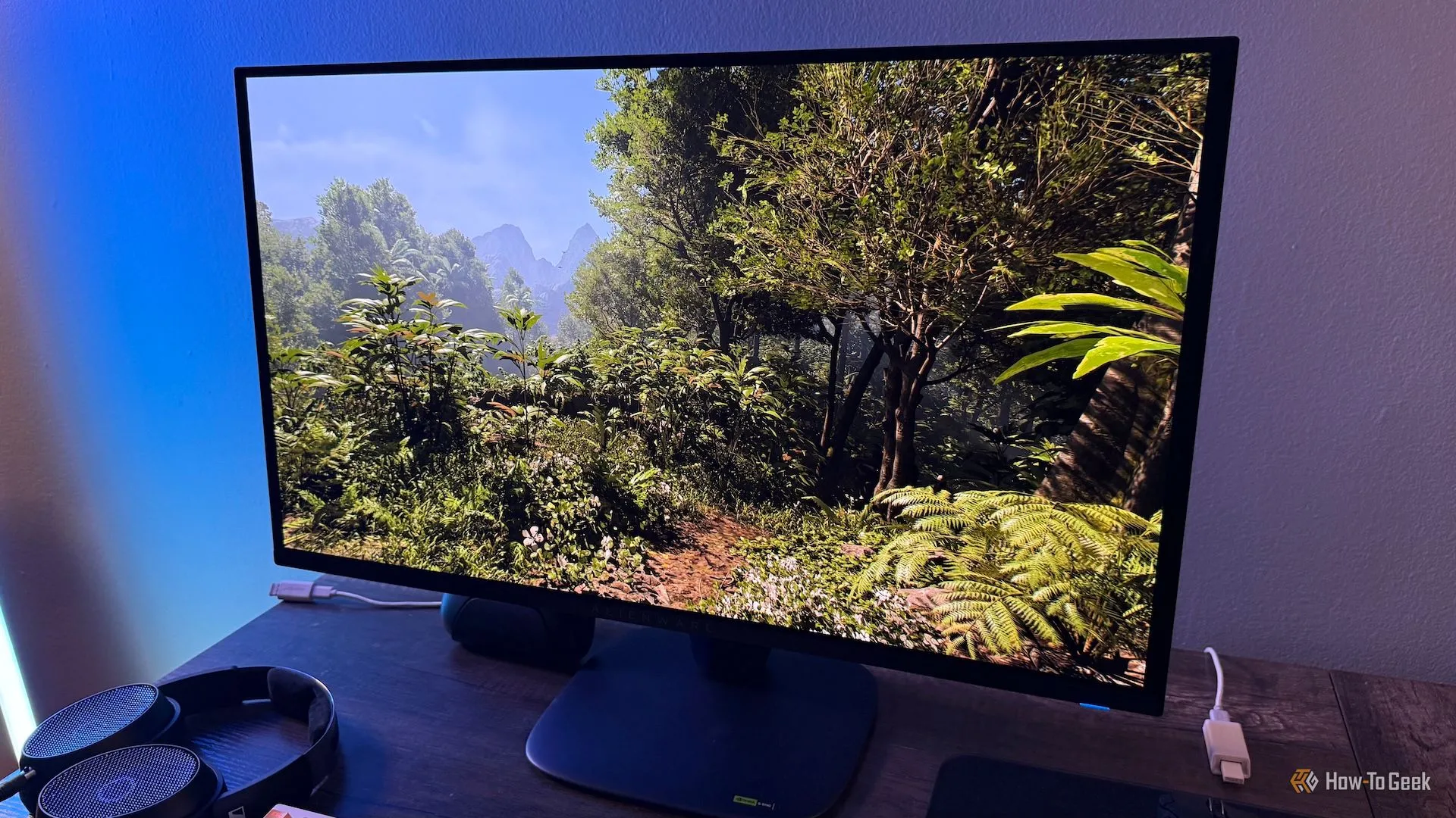 Hình ảnh rừng xanh từ trò chơi Indiana Jones hiển thị trên màn hình Alienware 27 4K QD-OLED (AW2725Q), minh họa trải nghiệm hình ảnh sống động.