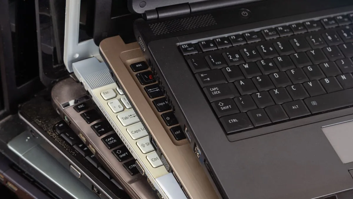 Một chồng các laptop cũ bụi bặm