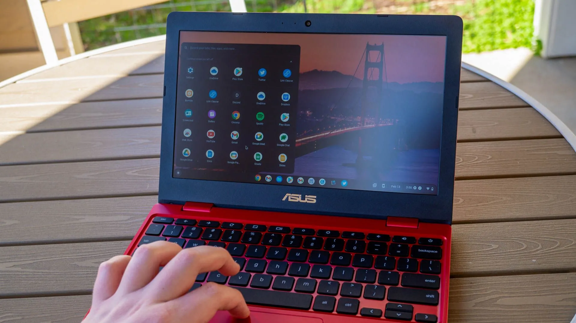 Người dùng đang sử dụng chiếc ASUS Chromebook 12 đặt trên bàn ngoài trời