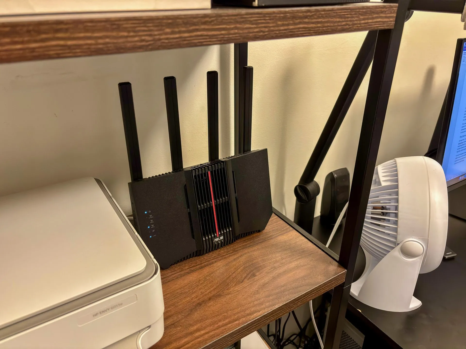 Router ASUS RT-BE92U được đặt trên kệ trong khu vực văn phòng, kết nối với máy tính và thiết bị ngoại vi